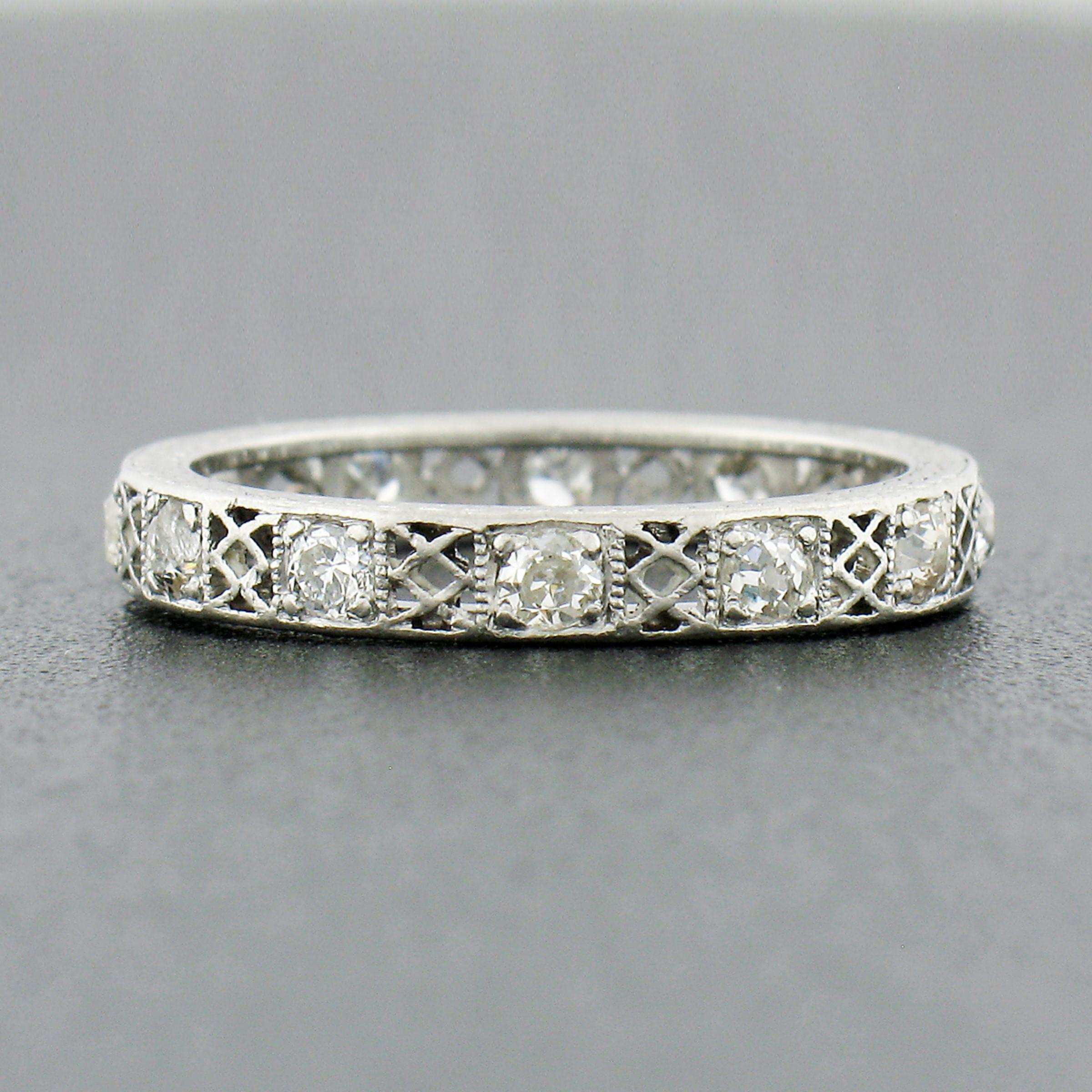 This RARE antique diamond eternity band ring was crafted from solid platinum during the art deco period. It features an alternating pattern of old European and old single cut diamonds neatly set throughout with open filigree work in between, giving