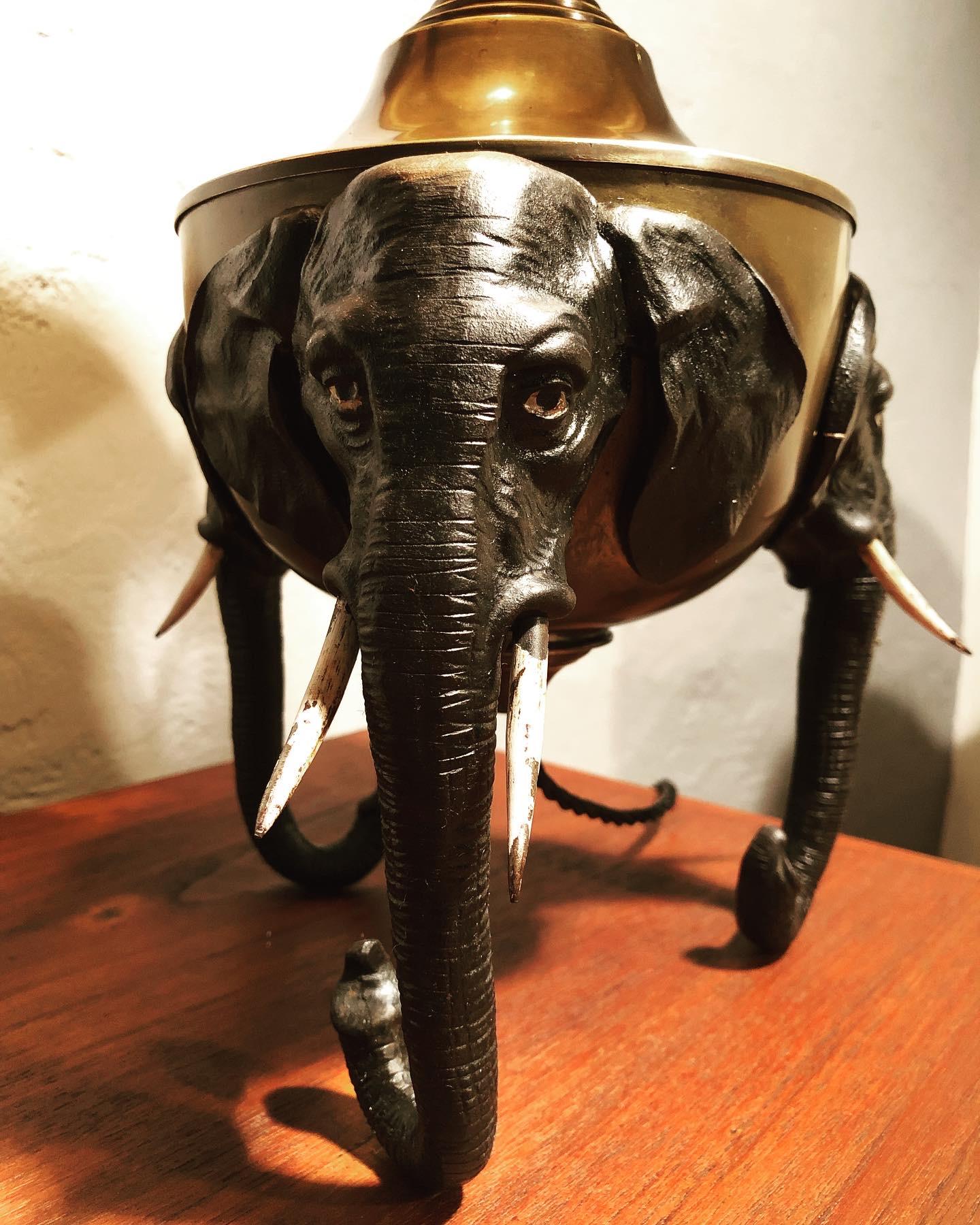 Rare antique Art Nouveau elephant lamp from the early 1900s.
Raised on 3 elephant heads in painted cast iron.
Original lampshade in brass with a great patina to the surface.
6 glass windows in the shade in green, blue, green and clear glass on top .