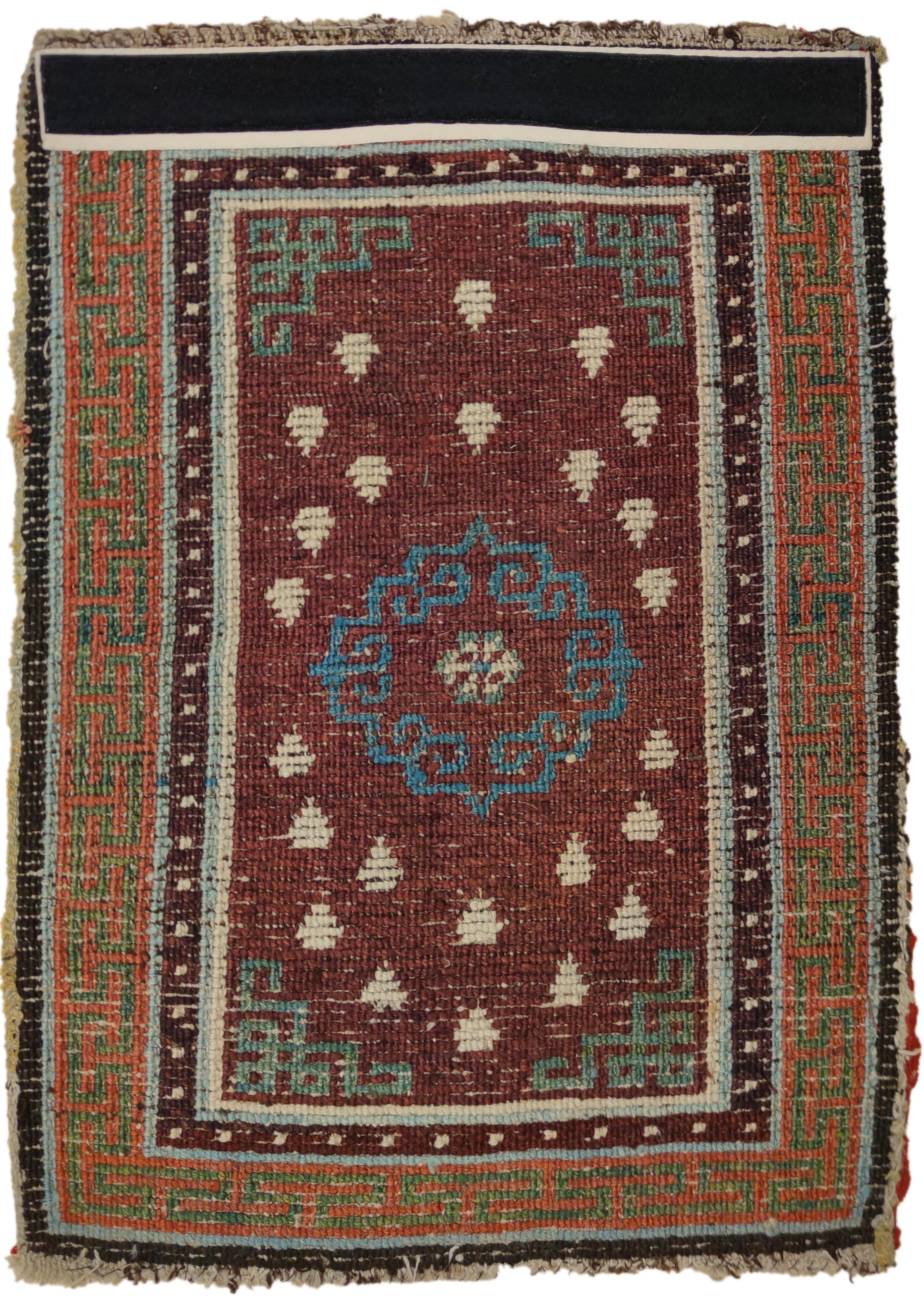 Tibetan rugs woven with thick squarish knots in brilliant colours are considered among the earliest, and are often referred to in Tibet as Gyantse. Here we see a centralised light blue archaic mandala set against an aubergine purple background