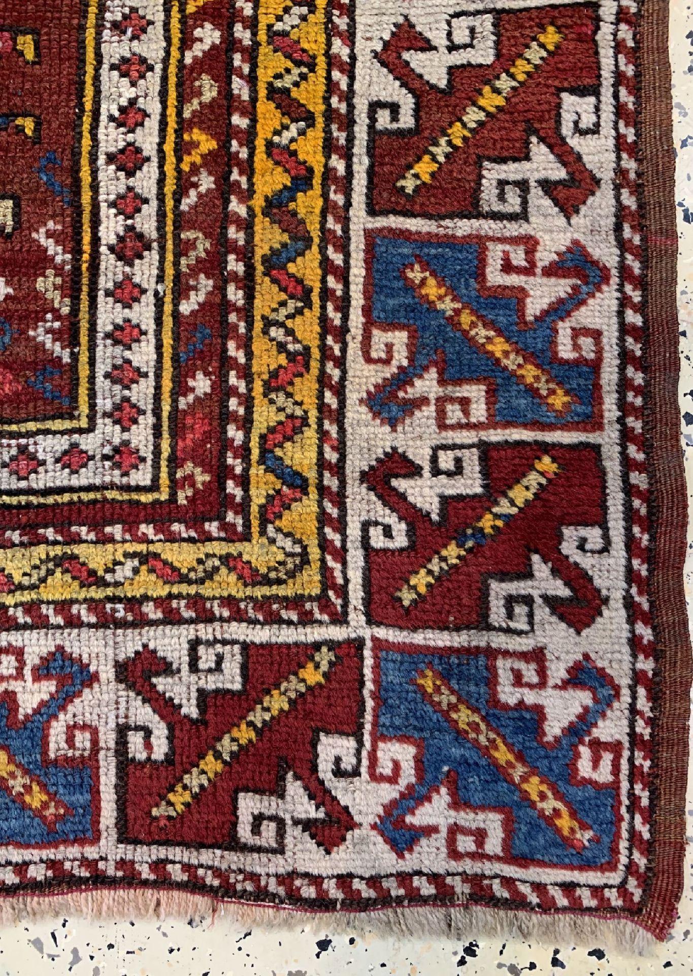 This wonderful niche carpet comes from Avunya, northwest Anatolia in the province of Bergama. It has the typical attributes of these rare carpets. The harmonious balance of the design, the deep red prayer niche and the wide, powerful white-ground