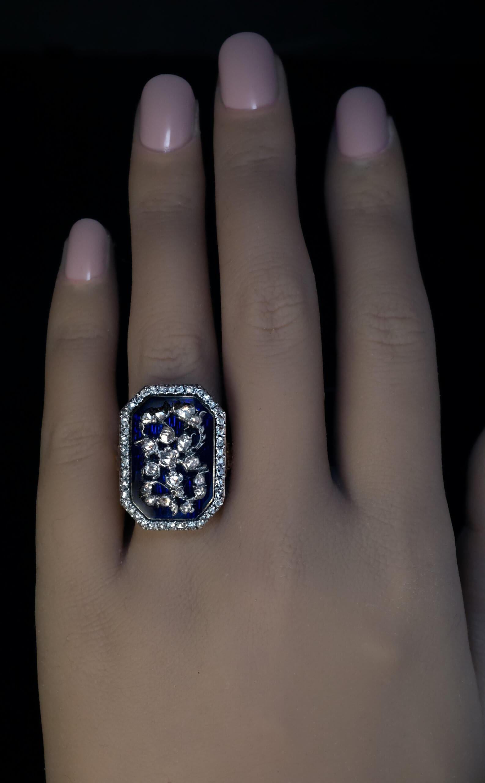 Circa 1780  This rare late 18th century ring is finely crafted in gold and silver. The ring features a cobalt blue guilloche enamel plaque applied with a floral motif silver applique embellished with rose cut diamonds. The enamel plaque is set in a