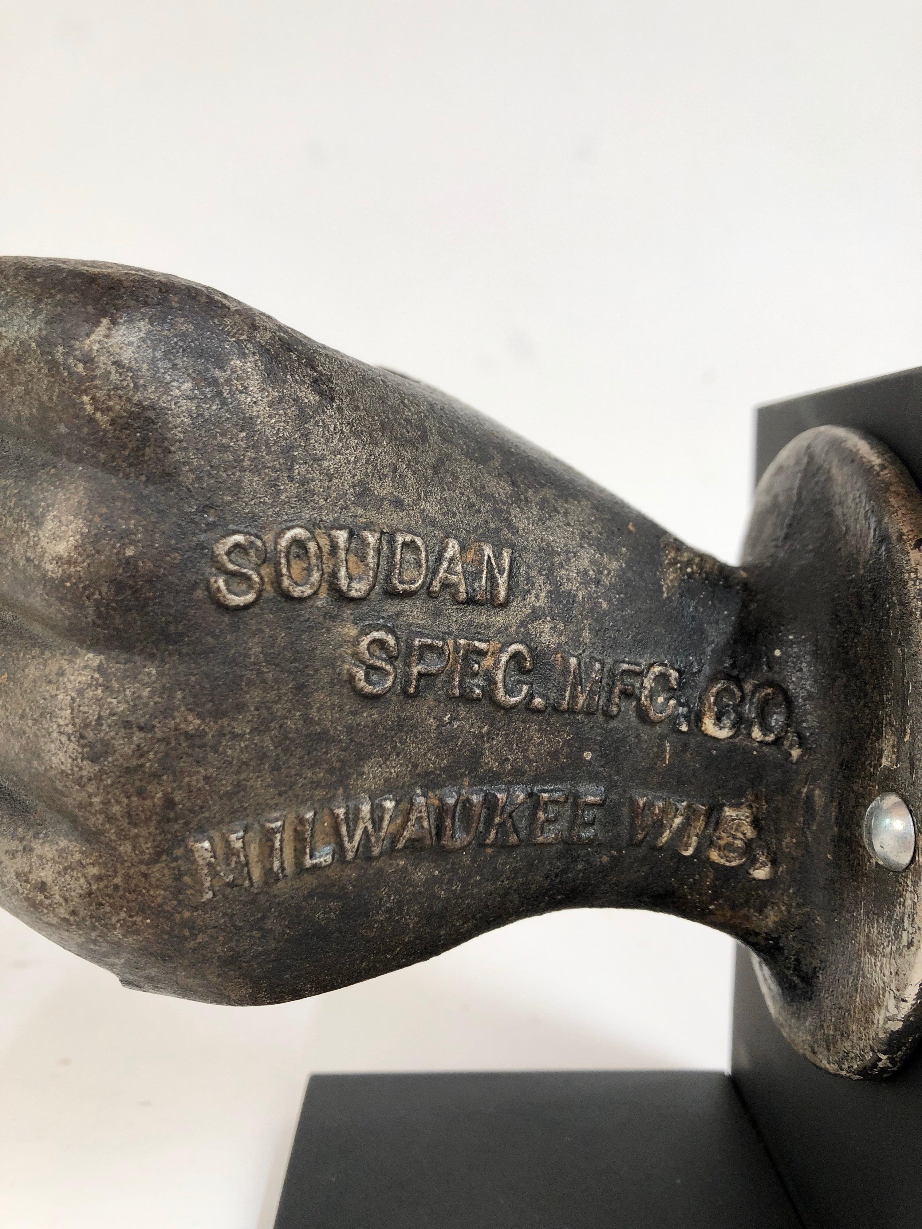 A rare antique life size cast iron closed hand shaped advertising piece made for the Soudan Spec. Mfg. Co. Milwaukee Wisc. Nicely detailed and proportioned. Mounted to a custom made steel stand. Original untouched surface. Measures: 6 1/2