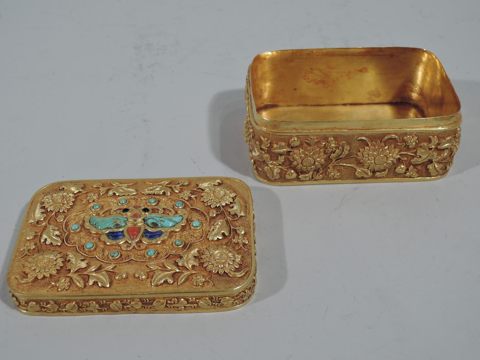 Antique Chinese gold covered box with semi-precious stones. Rectangular with curved corners . Finely chased and repousse ornament on stippled ground. Box and cover top have wraparound floral garland. Cover top has semi-precious stones inset in form