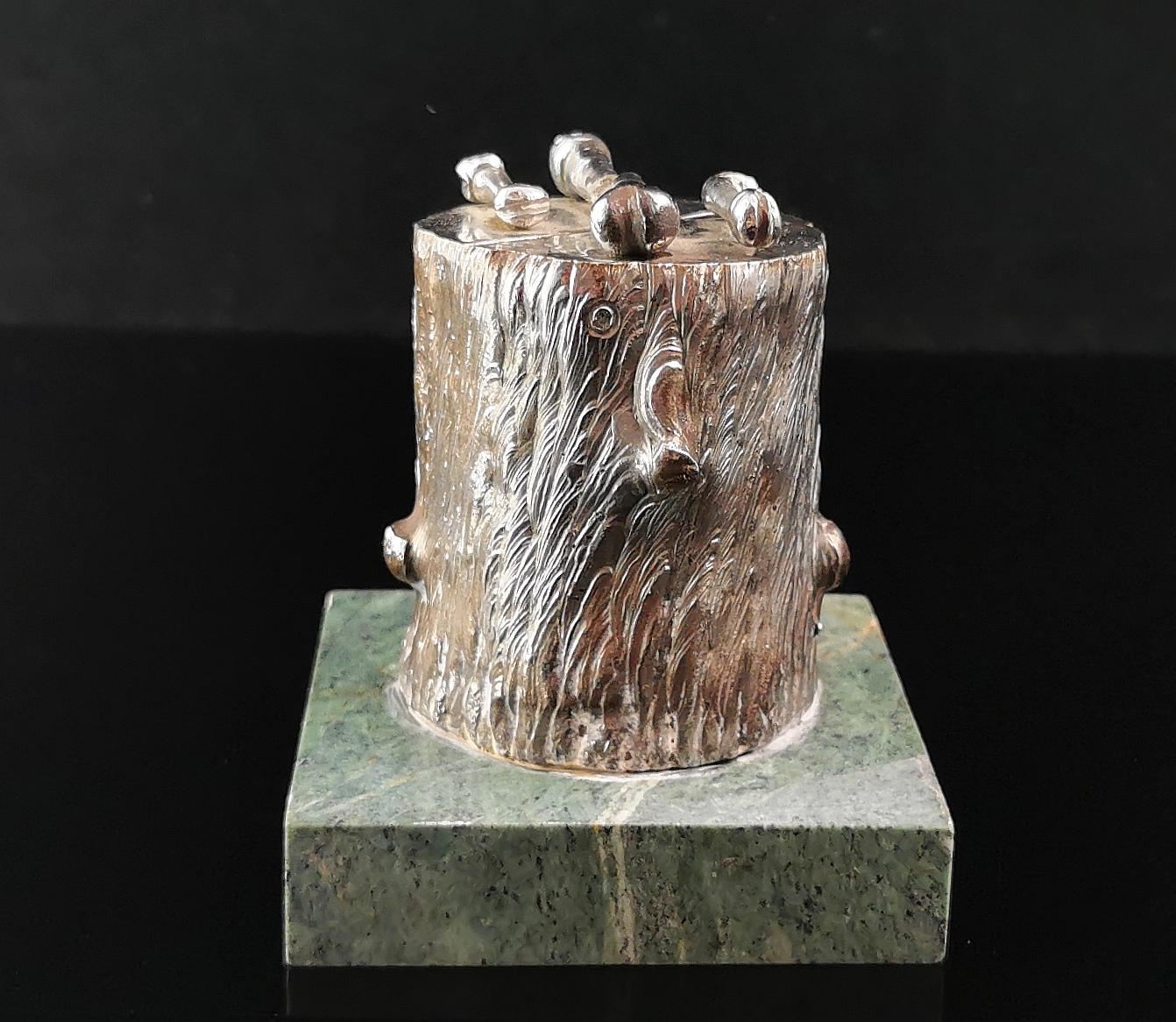 A rare antique desk model or sculpture.

It is designed as a chopping block, a large tree stump with an arrangement of bones on the top giving it a sinister feel.

It is a very heavy silver plated metal affixed to a square green marble base.

It has
