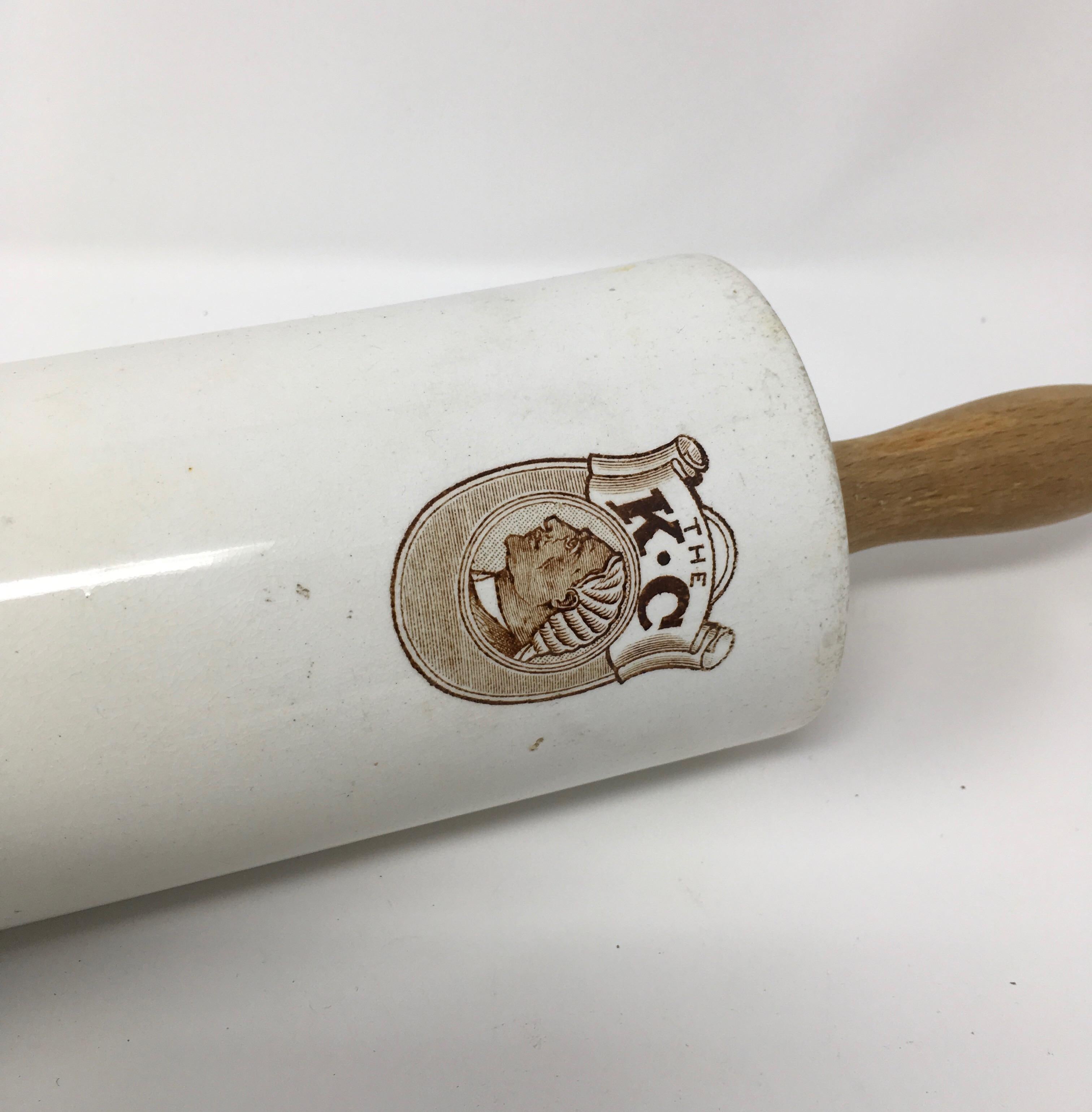 This is a rare English advertising ironstone rolling pin. The brown transfer depicts an emblem of a man and the lettering THE K C. Advertising rolling pins were made of ironstone and wood and this one is probably form the late 1800s. This rolling