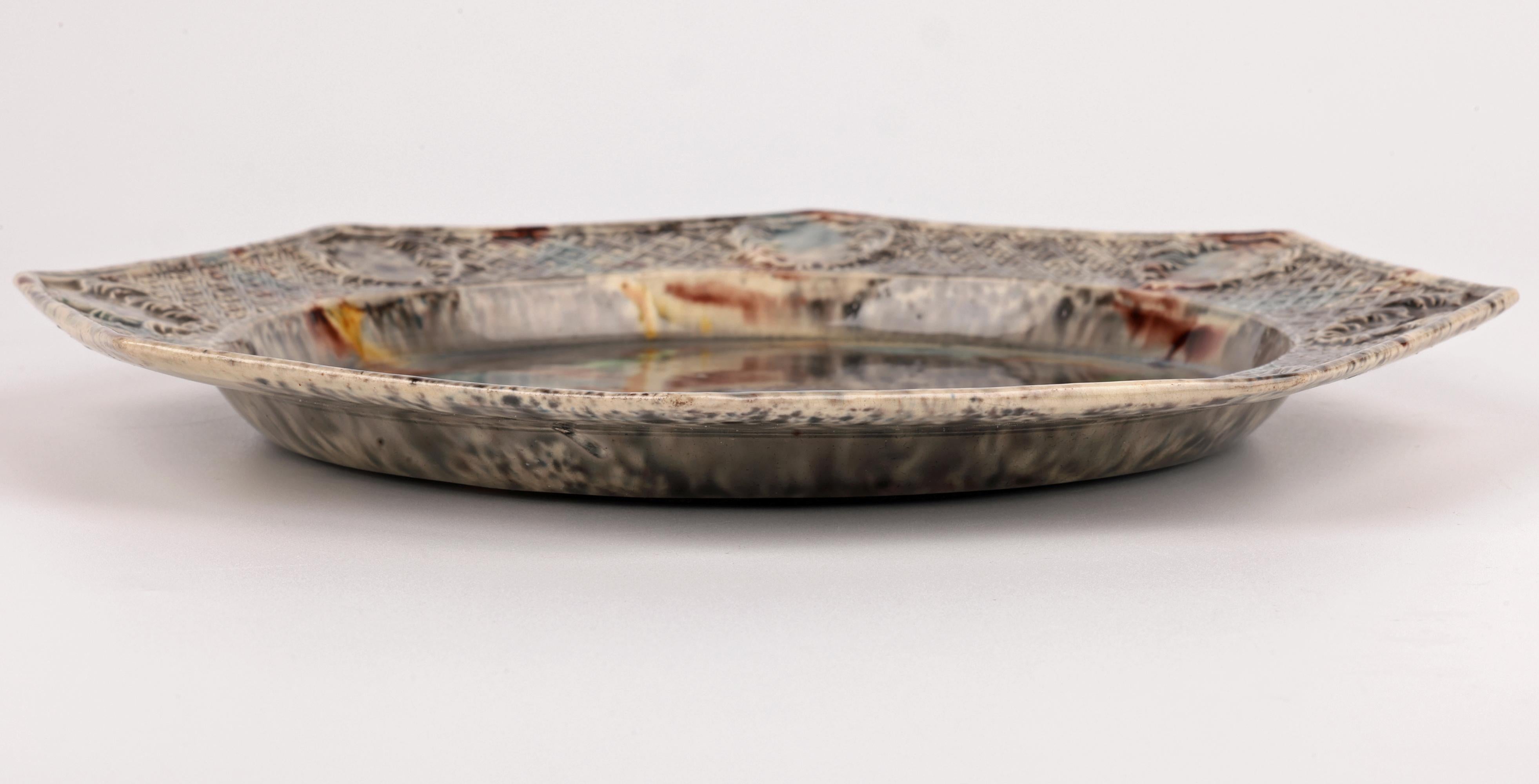 Rare assiette octogonale en poterie anglaise de type Whieldon datant d'environ 1750. L'assiette, légèrement et finement modelée, présente une profonde réserve centrale ronde avec un bord surélevé moulé en relief avec des rinceaux de feuilles d'angle