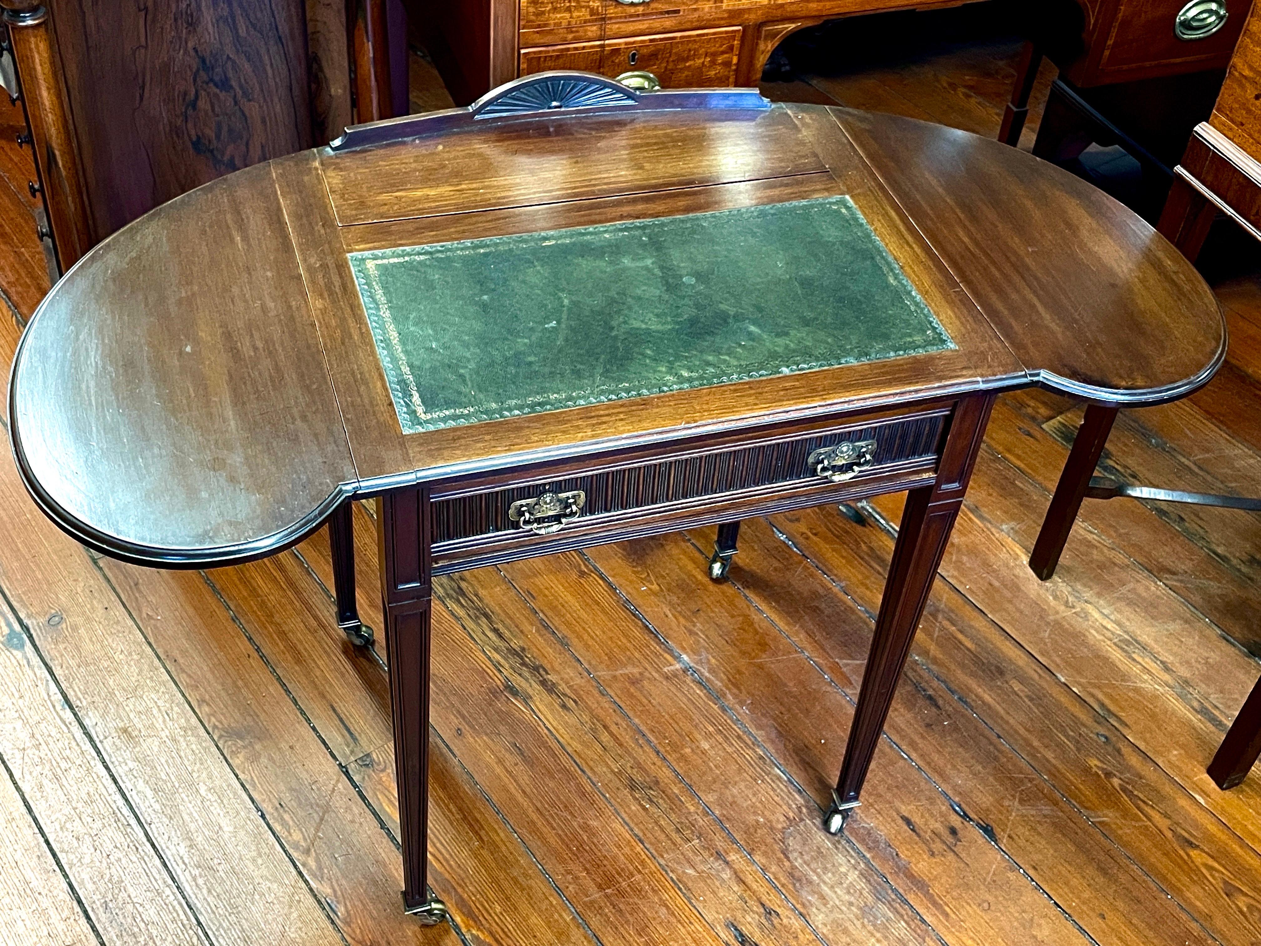 Rare and Unusual Antique English hand-carved solid mahogany and leather top Campaign Writing Table or Desk with kidney-shaped drop leaves or flaps.  The desk has a flip-top fitted rear with stationary slots, pen tray, double glass inkwells with
