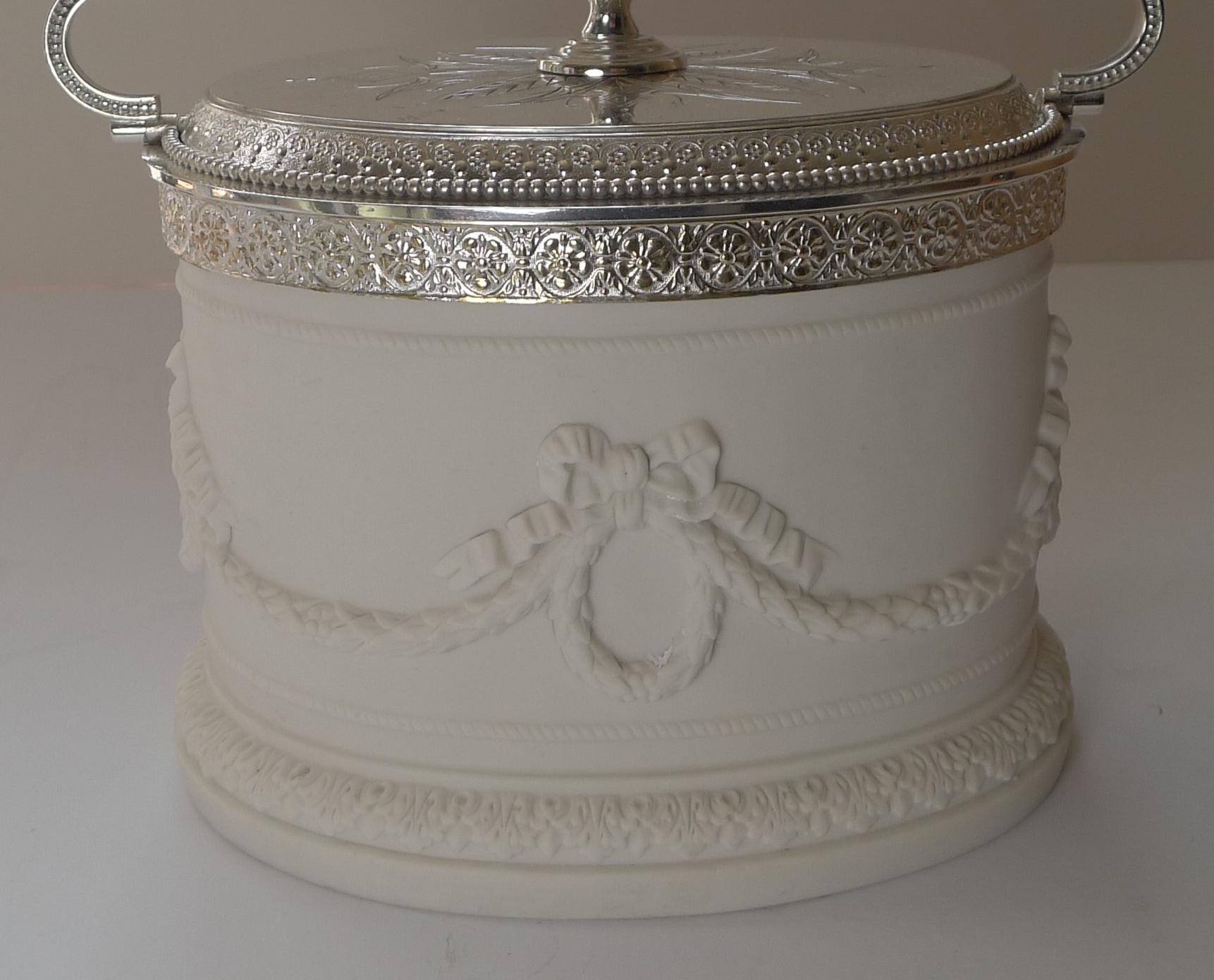 A rarely found Victorian biscuit box made from Parian with silver plated fittings dating to c.1880. 

Parian ware is a type of biscuit porcelain imitating marble. It was developed around 1845 by the Staffordshire pottery manufacturer Mintons, and