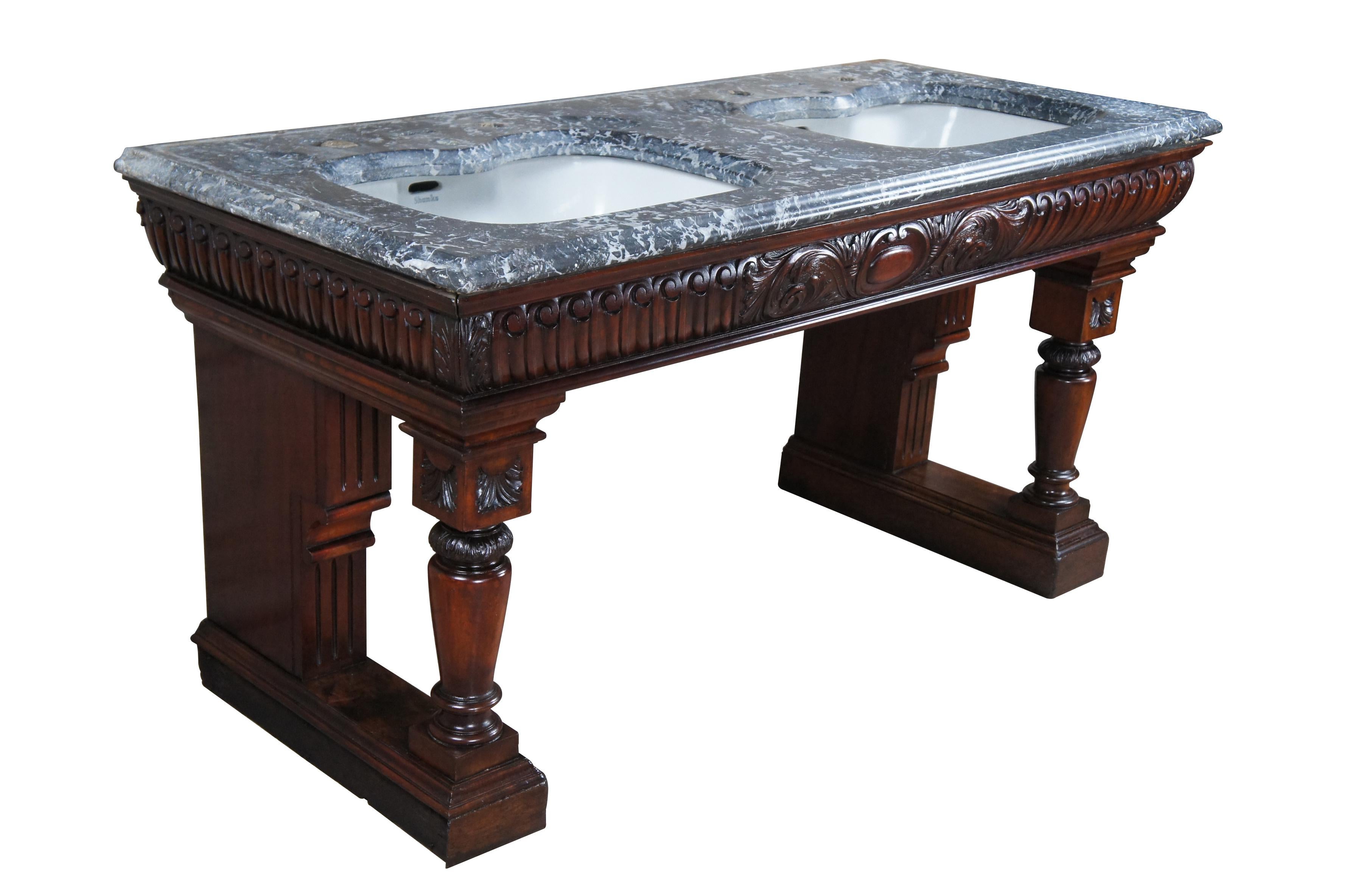 Un exquisito tocador doble de baño inglés de la época victoriana.  Presenta una encimera de mármol gris y blanco veteado con jaboneras festoneadas y dos lavabos de porcelana de John Shanks (Gran Bretaña).  La espectacular base de caoba presenta un
