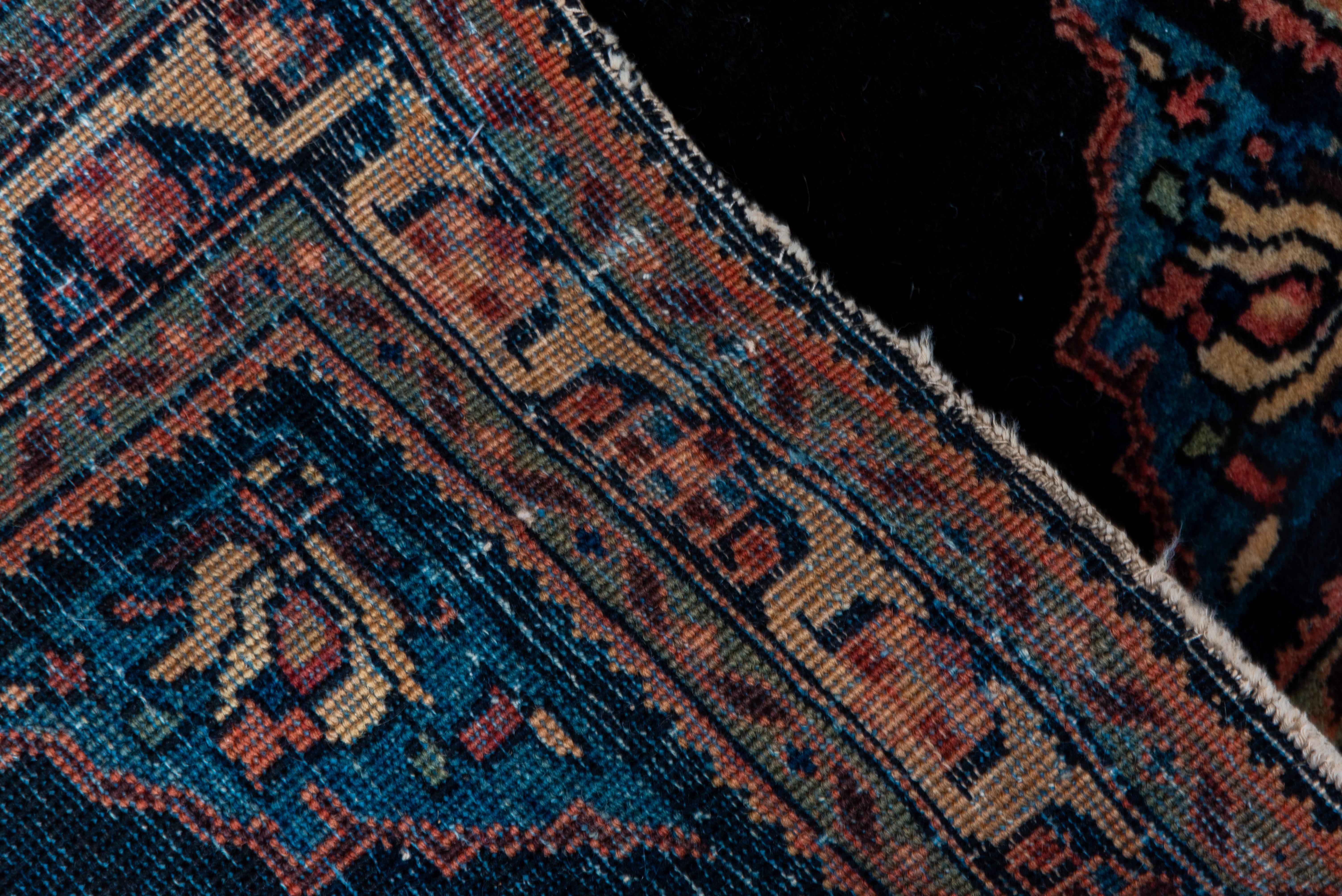 This is a finely woven, village micro-rug with all the essential aspects of something larger: intense navy open field, light blue extended corners with tulips; and a dark brown and ivory border with broad reciprocal lappets. Good condition.