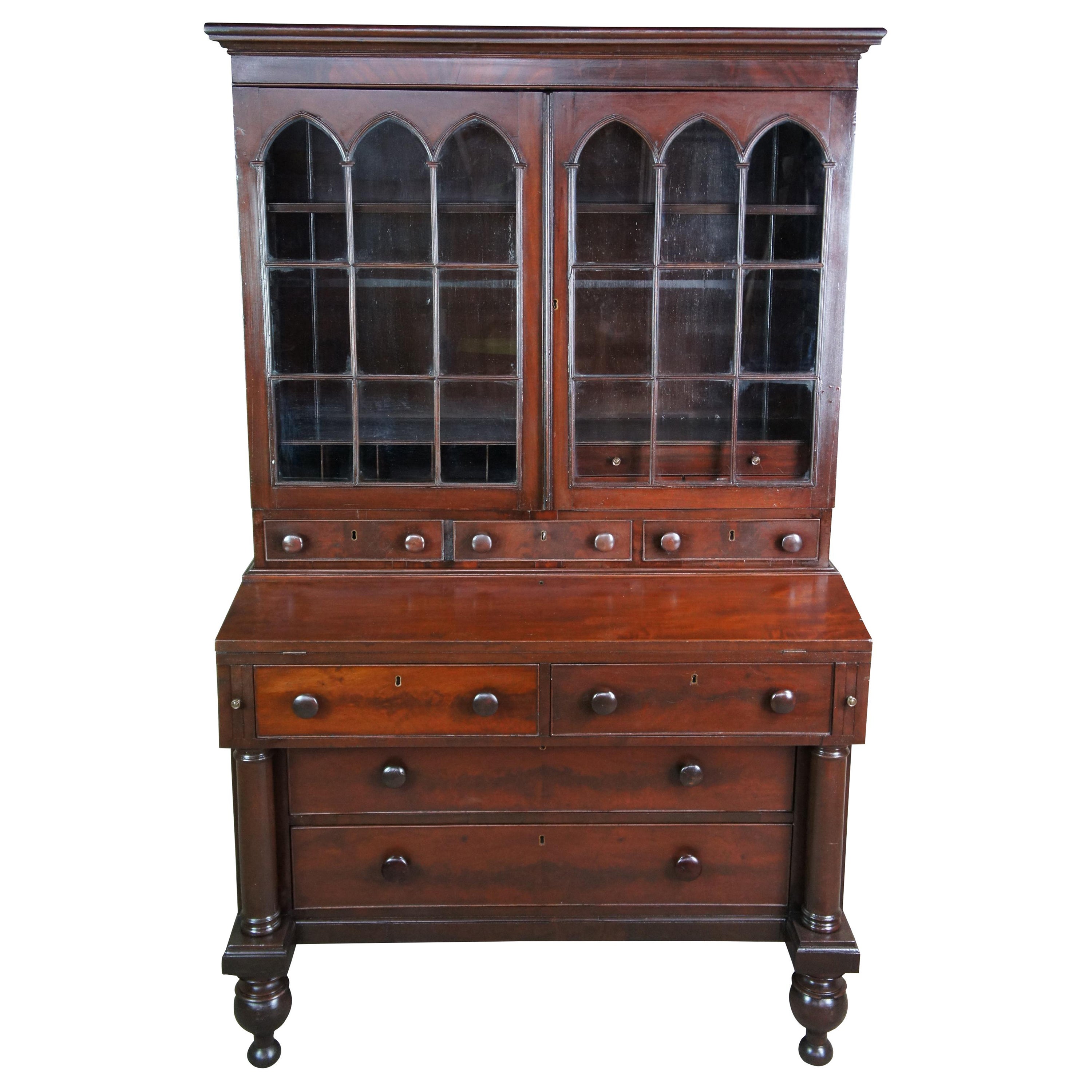 Segreteria e libreria in mogano del periodo federale, circa 1830. La libreria presenta un mobile con diciotto vetri ad arco gotico che si apre su due ripiani, scomparti e cassetti. Una superficie di scrittura ribaltabile si apre su una superficie di
