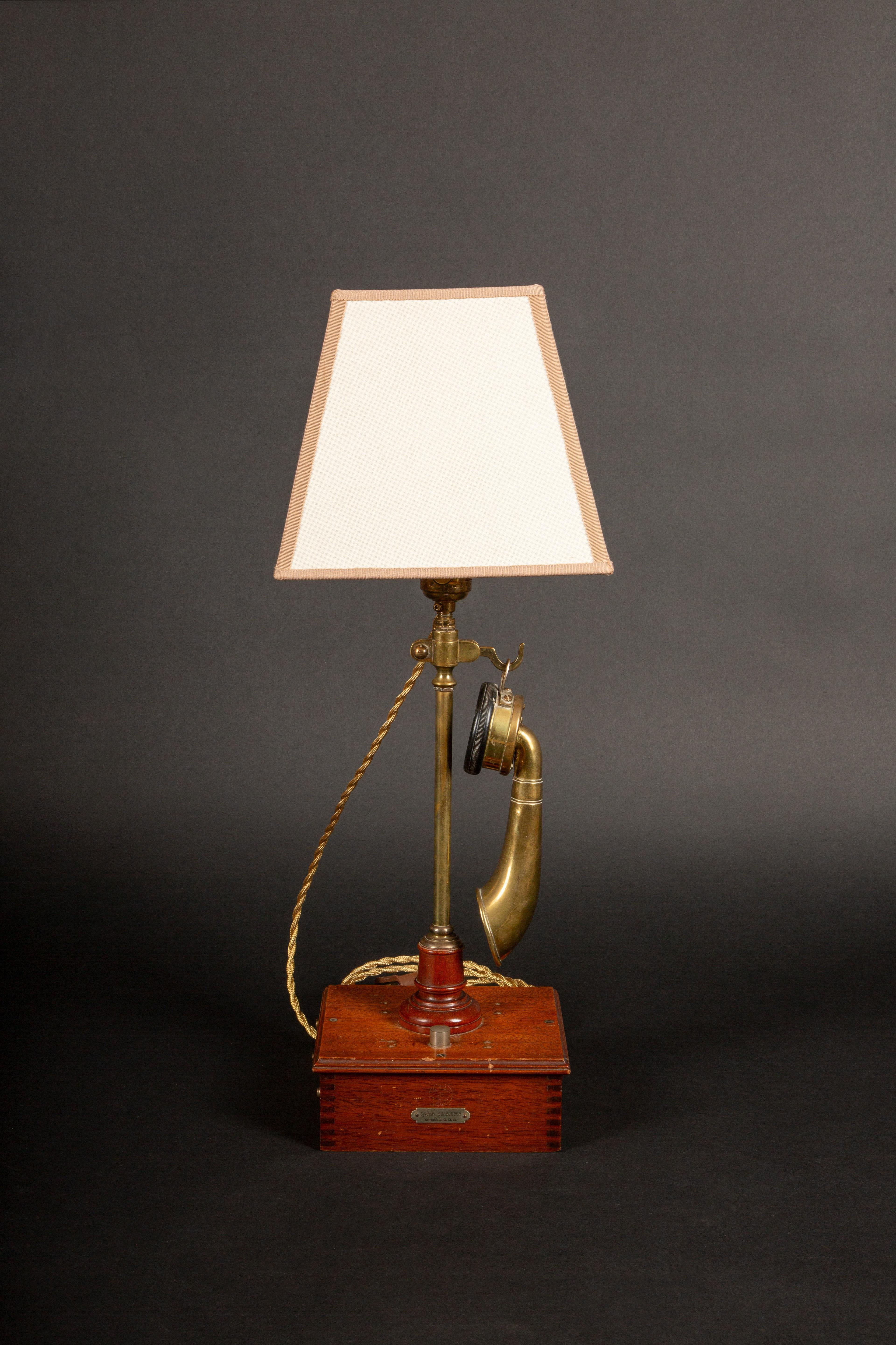 A rare and unique antique French brass candlestick telephone by Burgunder, creatively transformed into a functional table lamp. This exquisite piece features a brass fluted receiver typical of the early Berliner telephone system, made in Paris by