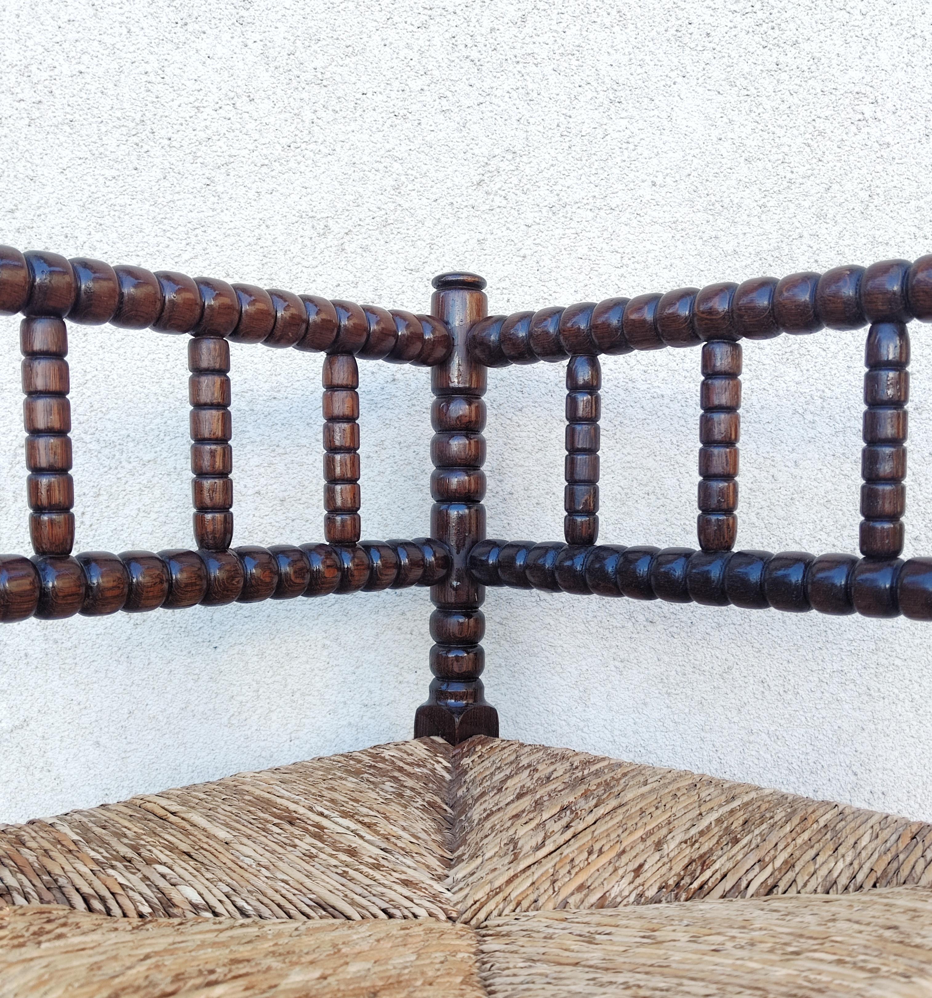 In diesem Angebot finden Sie einen französischen Bobbin Rush Eckstuhl aus dem Anfang des 20. Jahrhunderts.

Dieser Sessel aus geschnitzter Eiche im französischen Provinzialstil hat eine offene Rückenlehne und einen Sitz aus Binsen. Der Stuhl ist