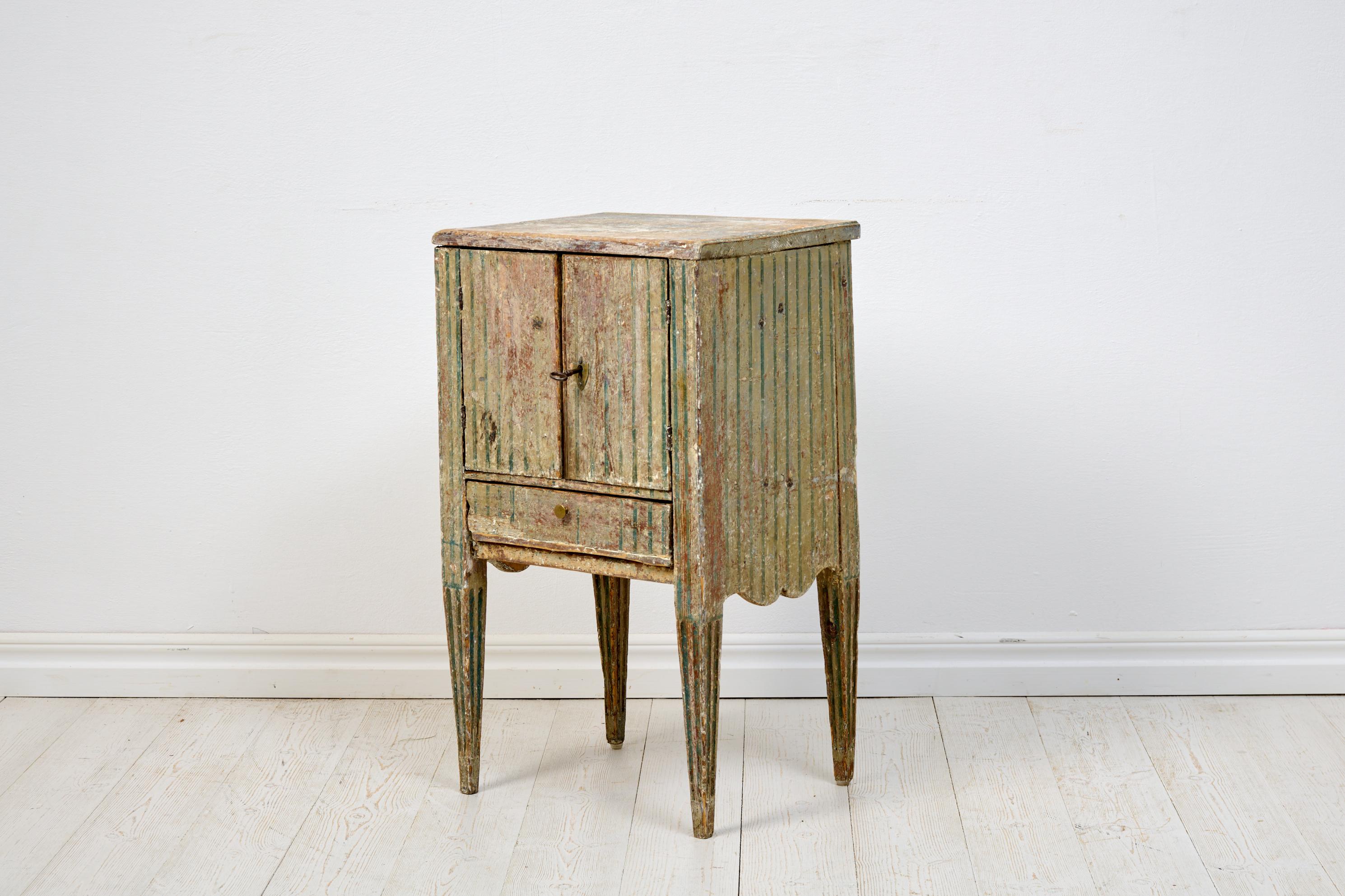 Seltener schwedischer antiker Nachttisch im gustavianischen Stil. Der Nachttisch wurde um 1790 in Schweden mit einem Rahmen aus massiver Kiefer hergestellt. Originallack und ein sehr ungewöhnliches Detail sind die aufgemalten Streifen. Die Farbe