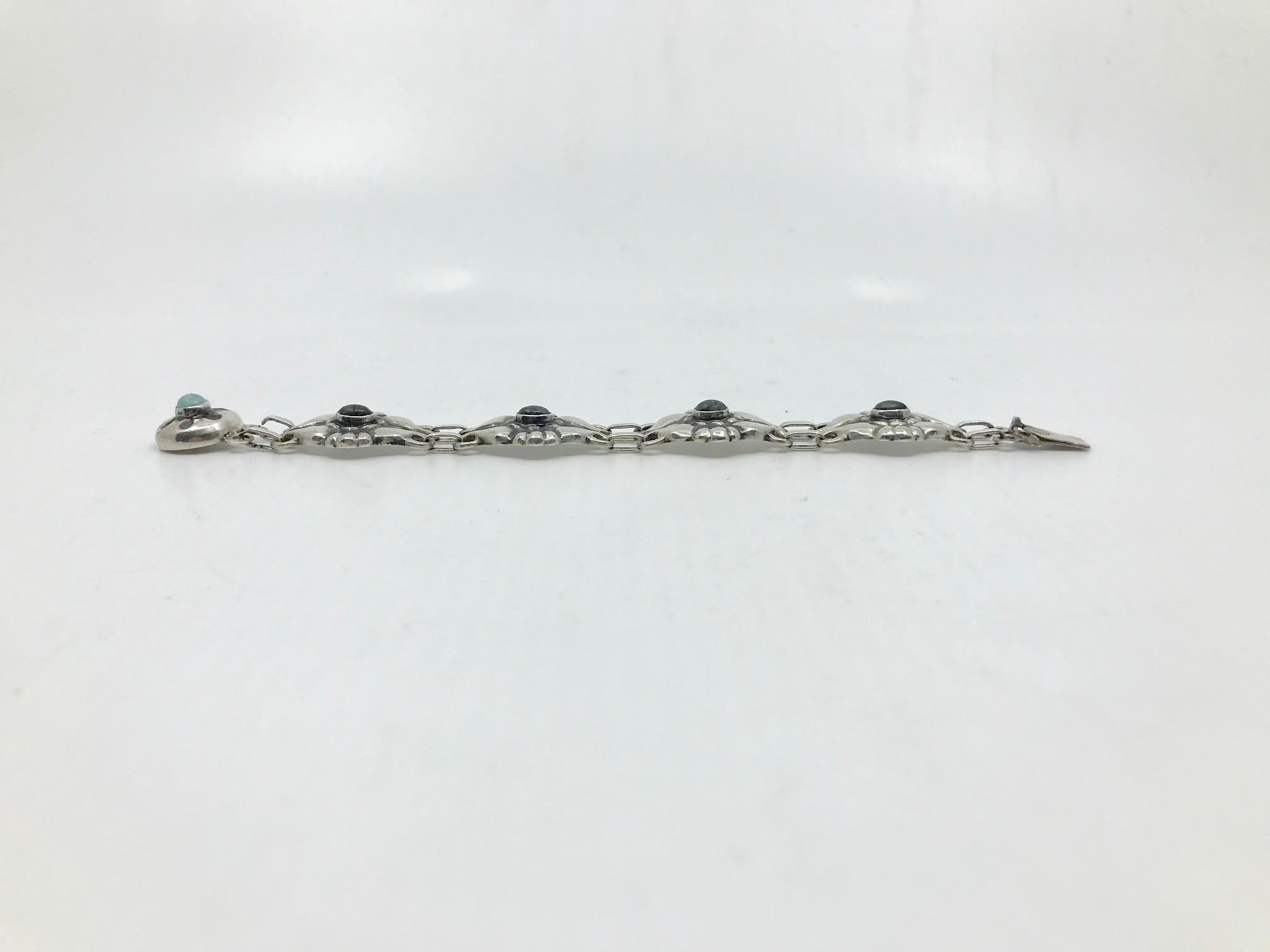 This is a very rare antique Georg Jensen silver bracelet with four cabochon set labradorites and one opal, design #4 by Georg Jensen.
Measures 6 3/8″ in length, the links are 13/16″ across (16.2cm, 2cm).
Antique Georg Jensen hallmarks from