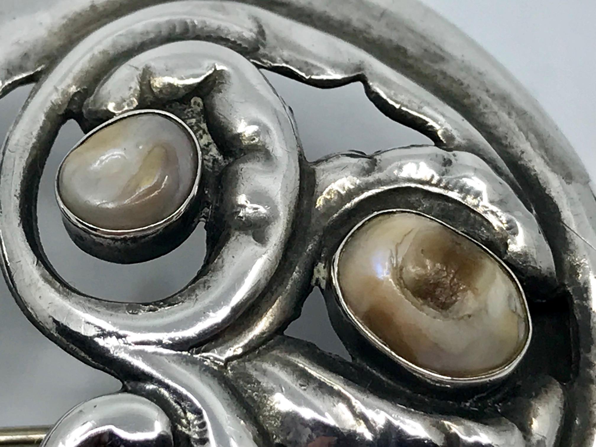 Rare antique silver Georg Jensen brooch set with four natural pearls, design #23 by Georg Jensen.
Measures 2 7/16″ x 1 15/16″ (6.1cm x 4.9cm).
Marked with the absolute earliest Georg Jensen hallmarks from 1904-1908, 826s.