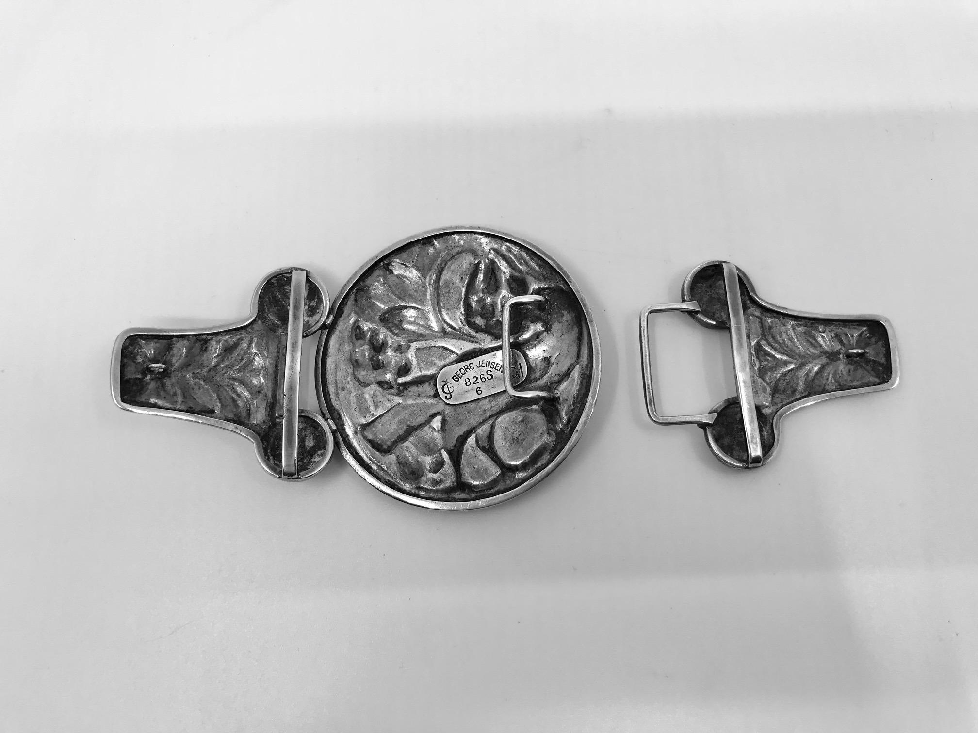 This is an extremely rare 826 silver Georg Jensen large belt buckle with bird and floral motif, design #6 by Georg Jensen himself.

Measures 5 5/8″ x 2 5/8″ (14.1cm x 6.7cm).

Antique Georg Jensen hallmarks from 1908-1914.