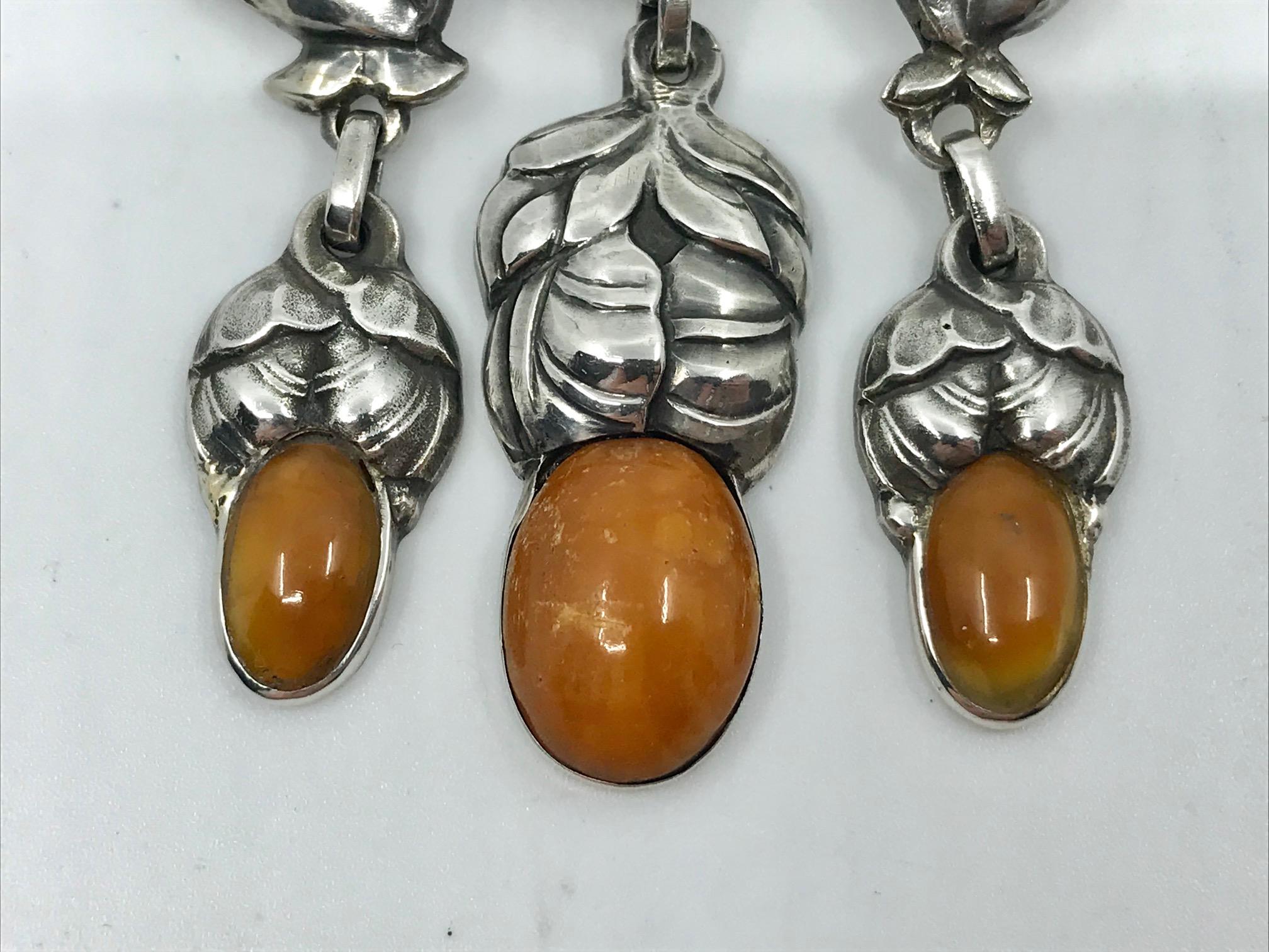 This is a rare antique silver Georg Jensen master brooch with seven cabochon set amber stones, design #98 by Gudmund Hentze from circa 1913.
Measures 3 1/4″ x 2 5/8″ (8.3cm x 6.6cm).
Antique Georg Jensen hallmarks from 1908-1914, 826s.