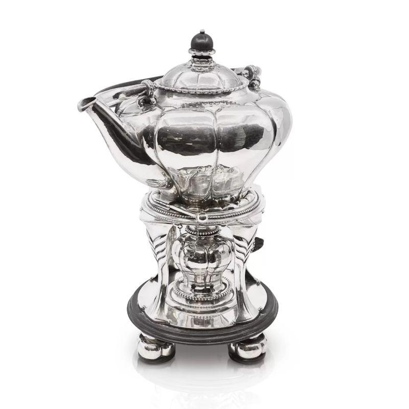 An antique 830 silver Georg Jensen hot water kettle topped with ebony finial in stand with burner, the stand is also part ebony , design #3 by Georg Jensen from circa 1914. This pattern is seldom seen, very Art Nouveau in design.

Additional