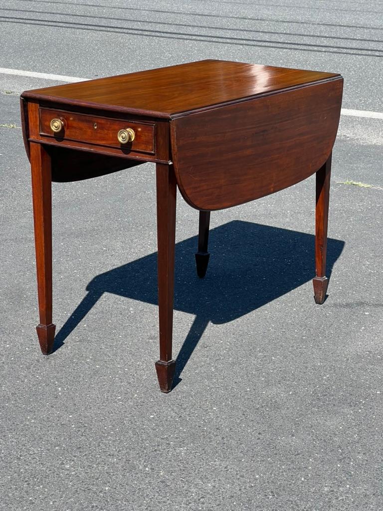 Introducing a rare and exquisite Antique George III Mahogany Drop Leaf Table with Spade Feet, a stunning example of the fine craftsmanship and timeless elegance of the George III period. This versatile table, dating back to the late 18th century, is
