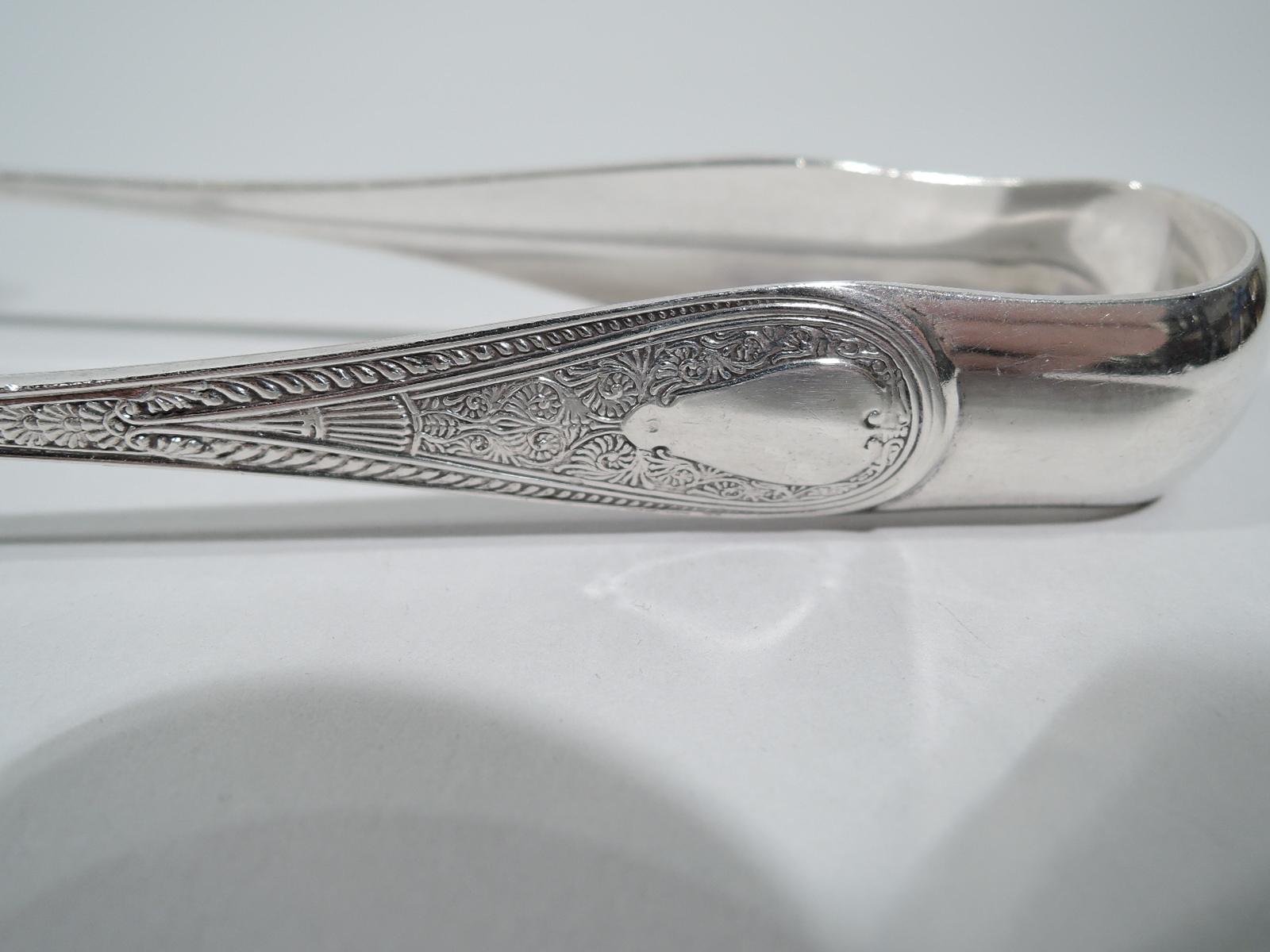 Rare Hindostanee sterling silver ice tongs. Made by Gorham in Providence. U-form with gilt jaws, of which one claw-form and the other flower head. Terminals in the desirable pattern that was first produced in 1878. A very nice early piece. Fully