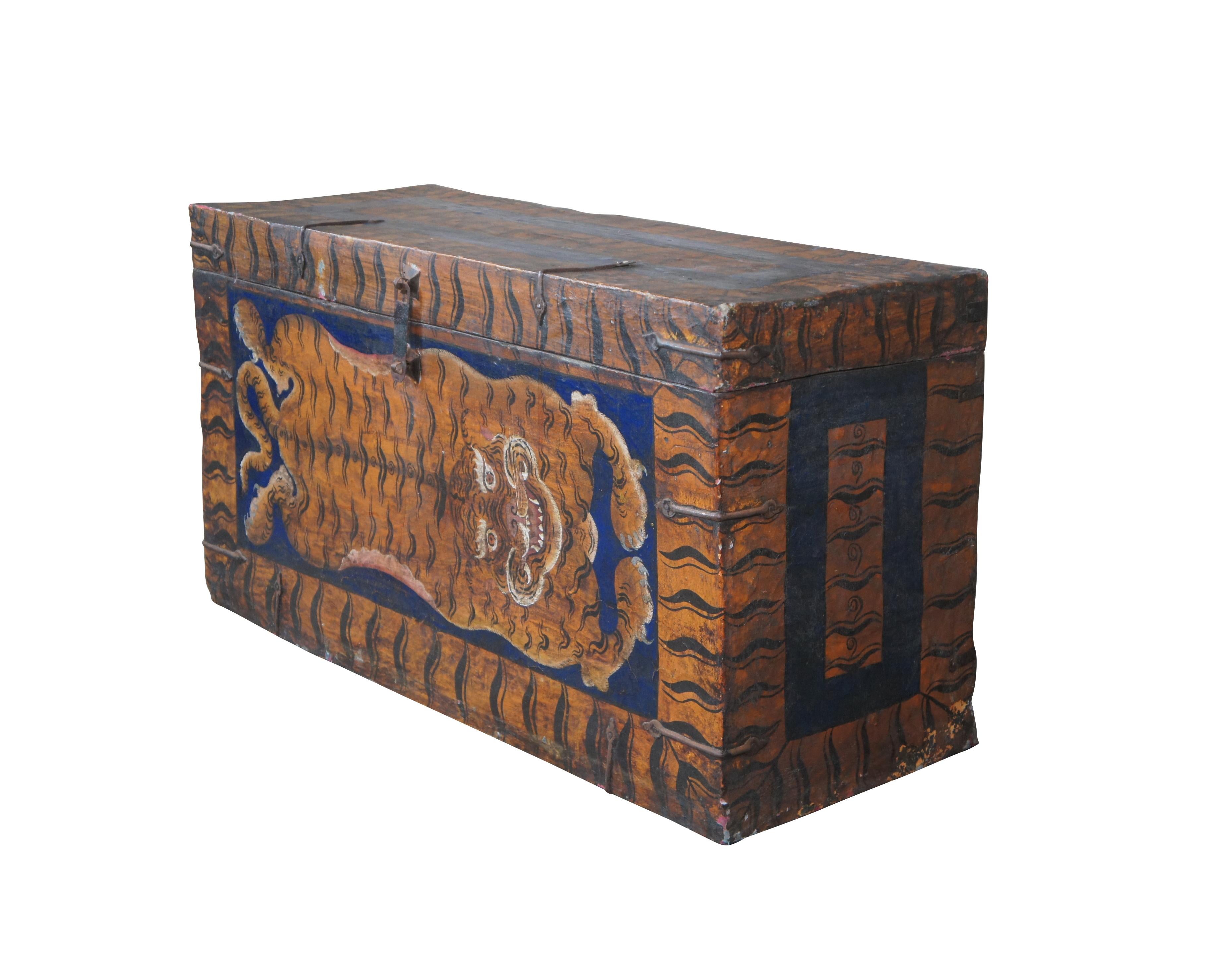 An impressive Tibetan storage from the first quarter of the 20th century. A wooden frame richly finished with lacquered leather hide and banded iron hardware. The front is hand-painted with a tiger at the center and framed in tiger stripes. The