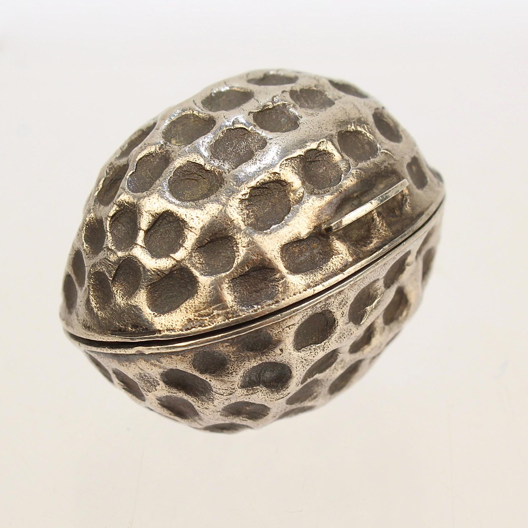 A very rare English sterling silver nutmeg grater.

Modeled as a walnut formed body and with a cover that reveals a hinged steel grill or grater.

The interior rim bears hallmarks for Hilliard & Thomason.

A fine addition to any nutmeg grater