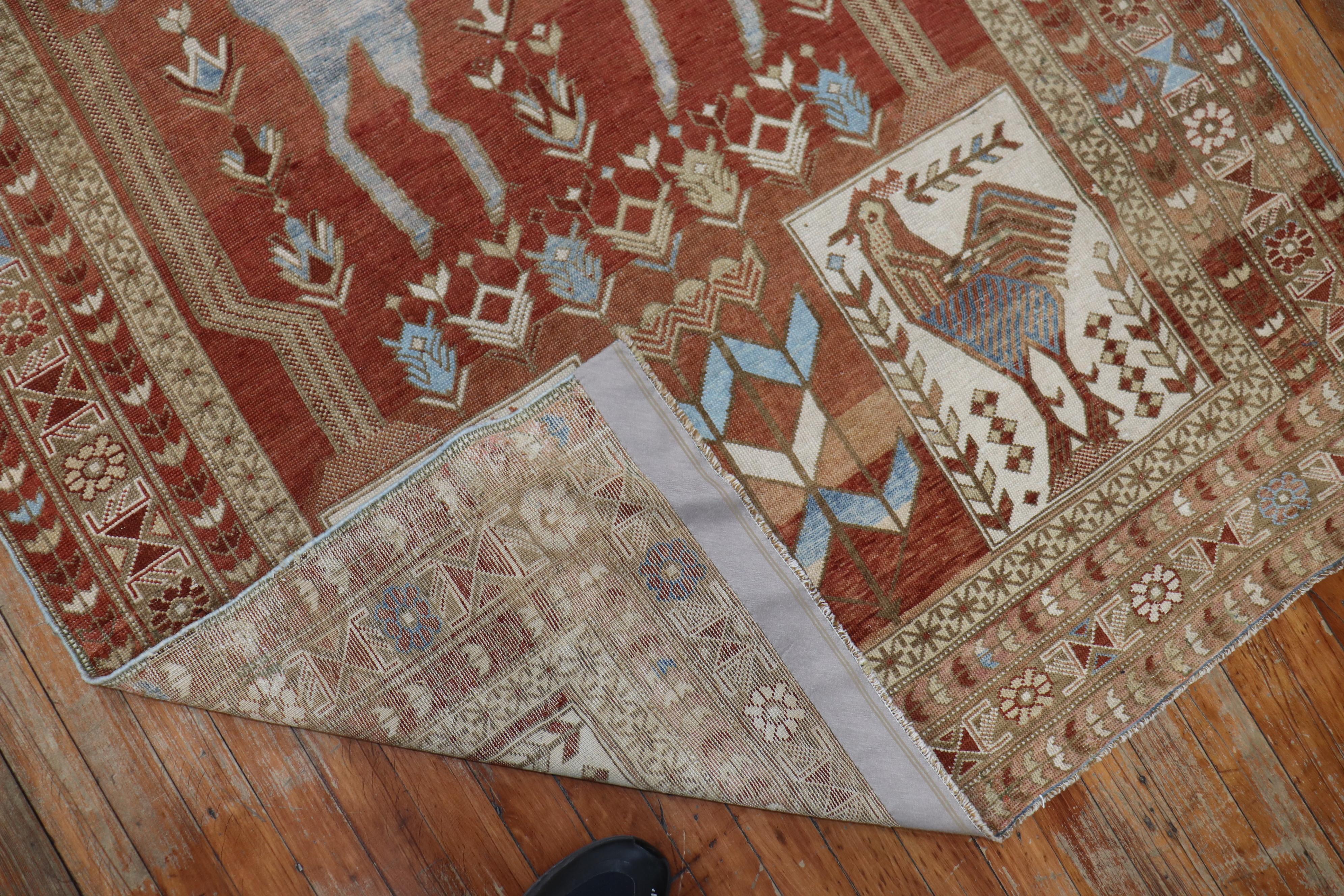 A fine rust colored Caucasian rug depicting a large light blue colored horse and 4 roosters dated 1948.

Measures: 4'3
