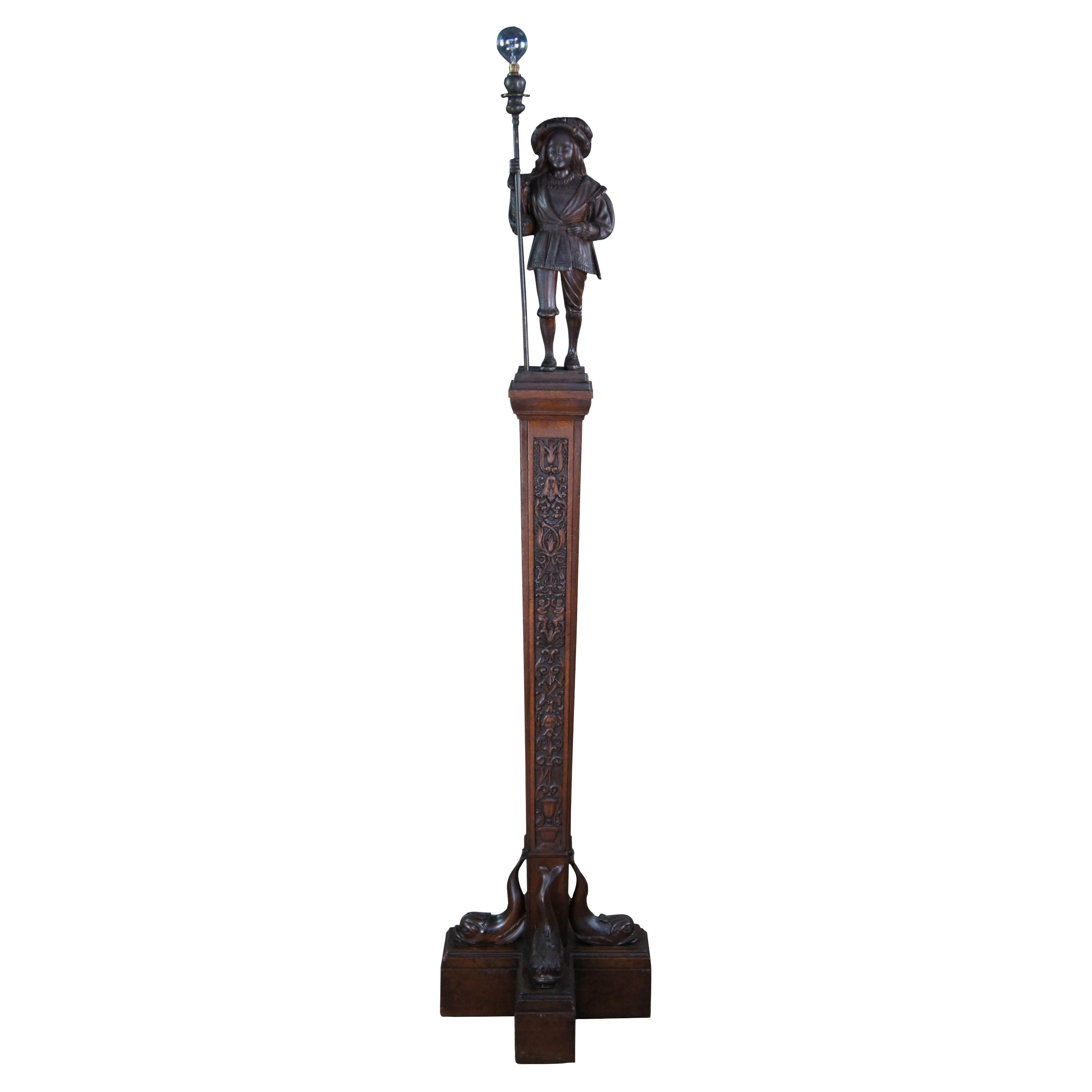 Una lampada da terra in legno di quercia intagliato, rara e unica nel suo genere, risalente agli anni '20 circa. Scolpito meticolosamente con dettagli sorprendenti. Presenta una guardia svizzera con bastone da torciere in cima a una colonna araldica