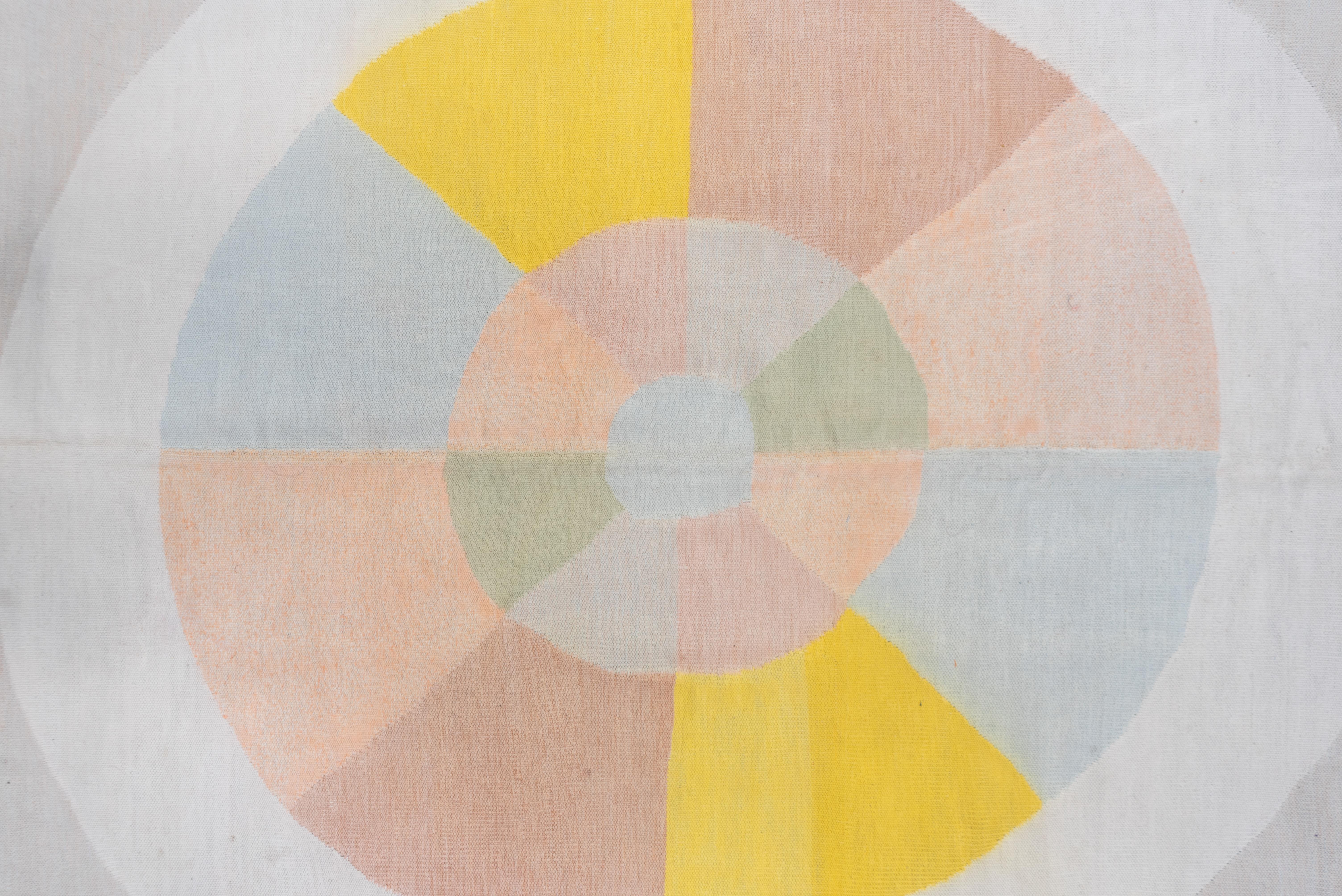 This all-cotton construction tapestry woven square carpet shows a neutral field with off white quarter circle corners and a round off white central medallion with a pie cut layout emphasizing a crisp canary yellow. Dusty pink plain border. Good