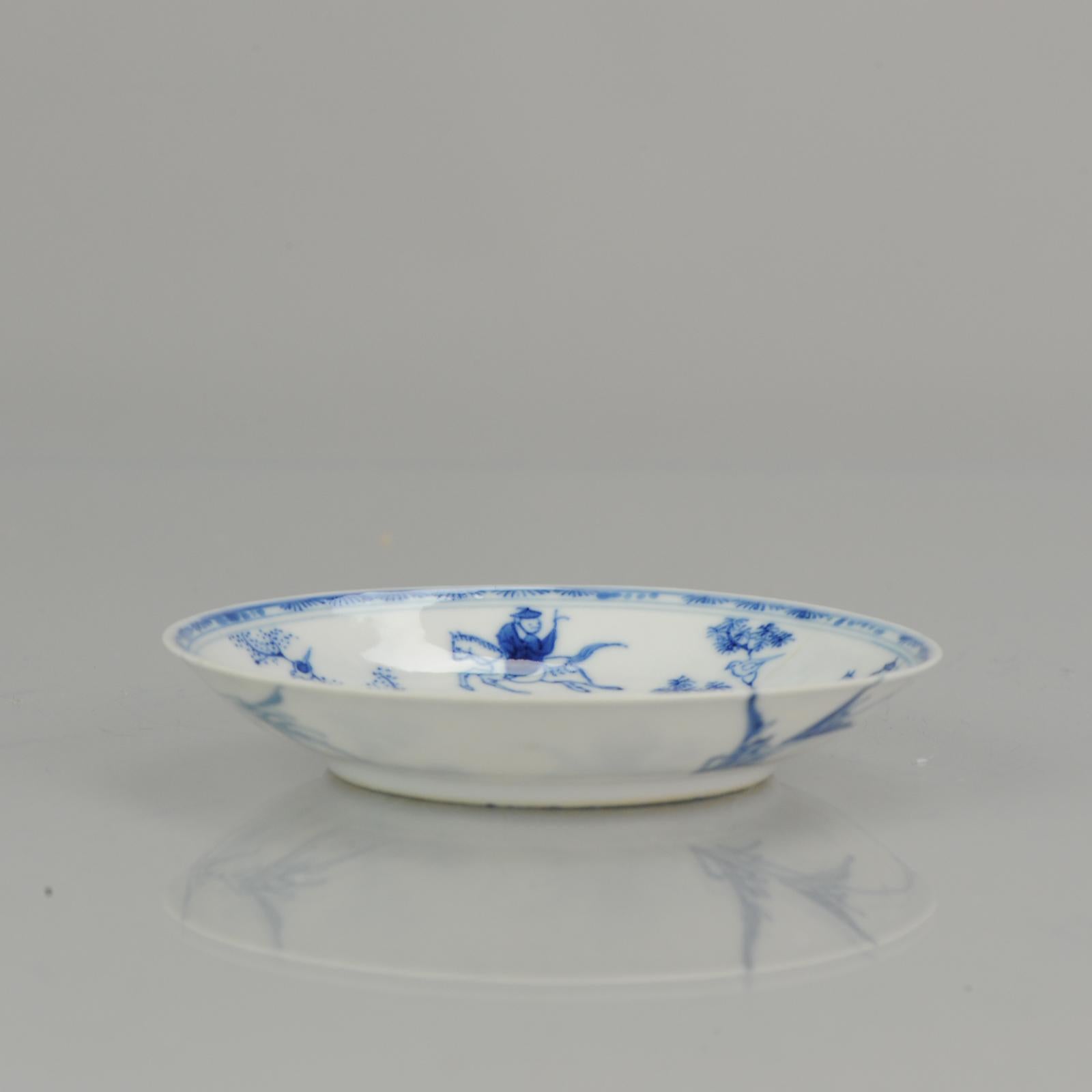 Lovely thinly potted antique Chinese porcelain saucer and cup with a central decoration of a person on horseback next to a tree with a bird in it, executed in a charming underglaze blue. In the border a decoration of patterns identical to those in