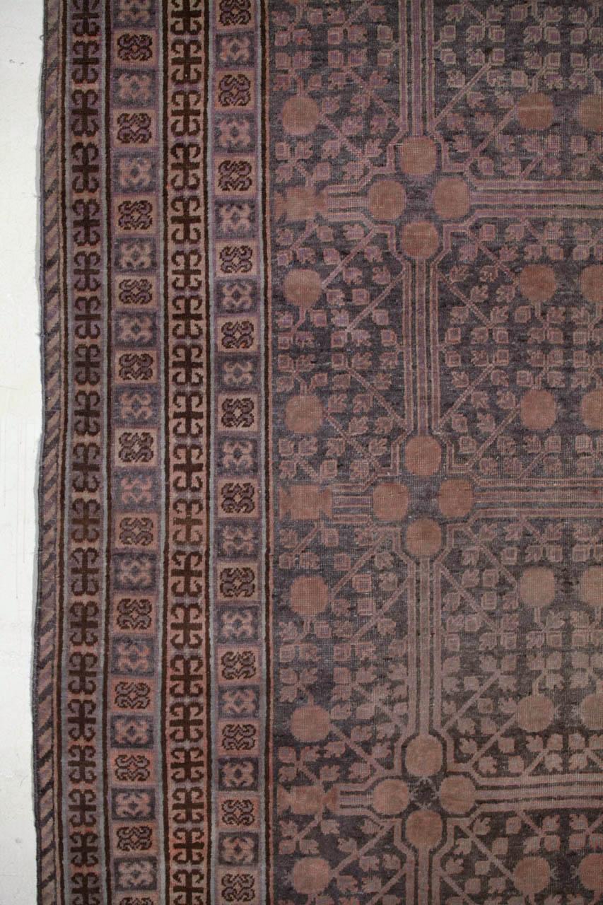 Stunning antique East Turkestan Khotan rug, with a pomegranate trellis overall within a series of reciprocal geometric stripes.
Period: circa 1920 
Country of origin: East Turkestan

Measures: cm 380 x 195.