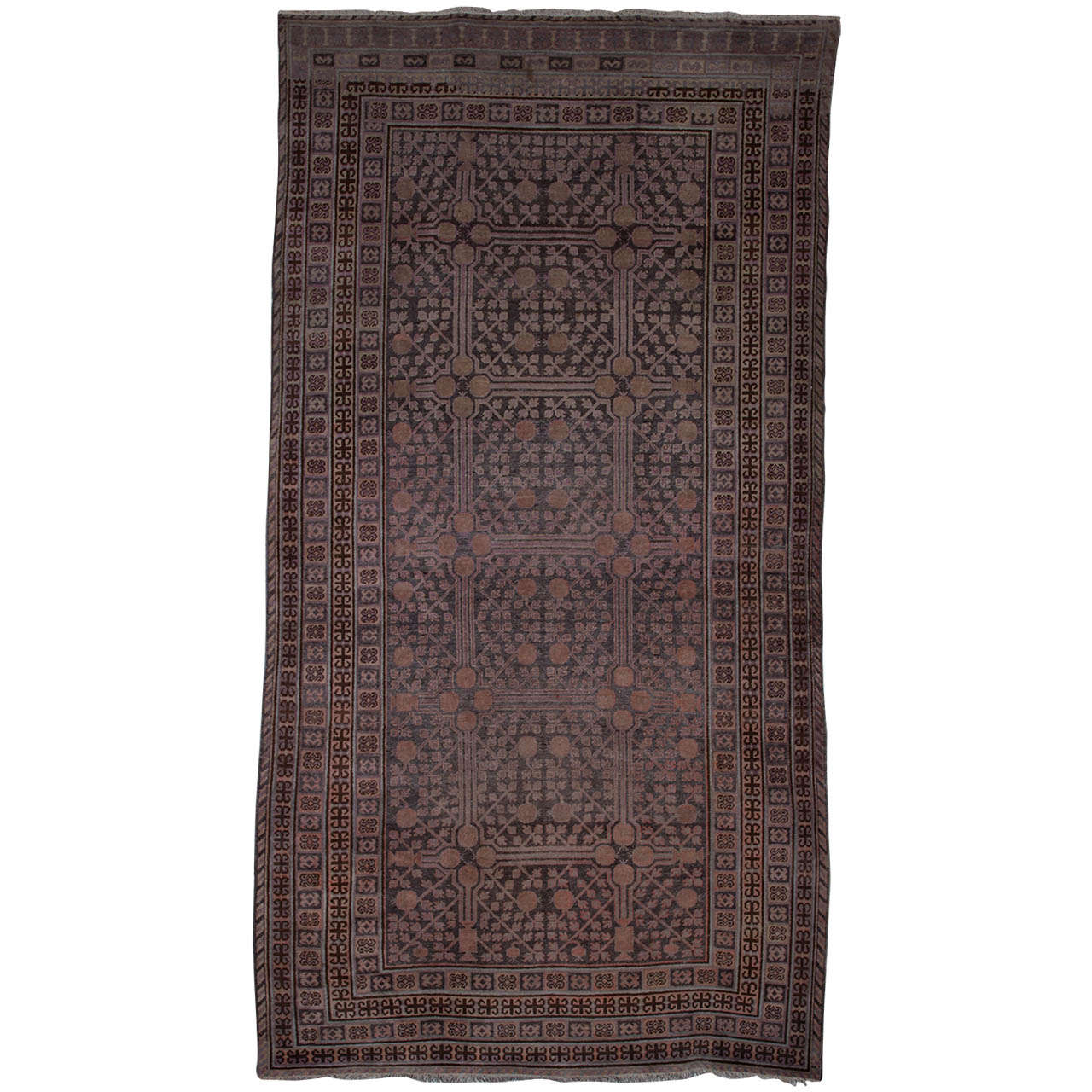 Stunning antique East Turkestan Khotan rug, with a pomegranate trellis overall within a series of reciprocal geometric stripes.
Period: circa 1920 
Country of origin: East Turkestan

Measures: cm 380 x 195.