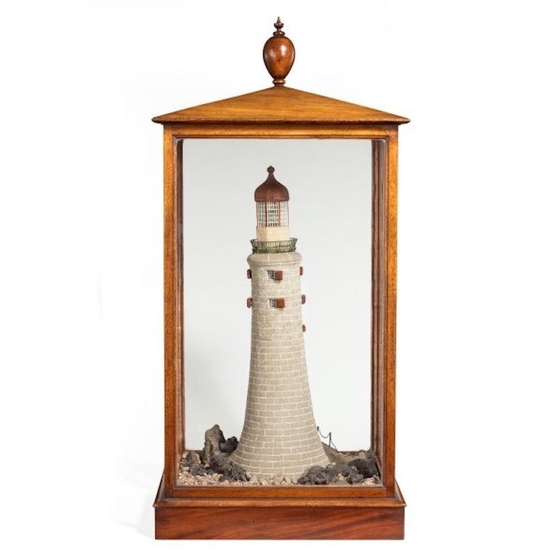 A rare 19th century cork model of the Eddystone lighthouse, which was designed by John Smeaton, within a glazed mahogany case surmounted by a turned finial, the model of the lighthouse with amazing detail. When shining a light into the two open