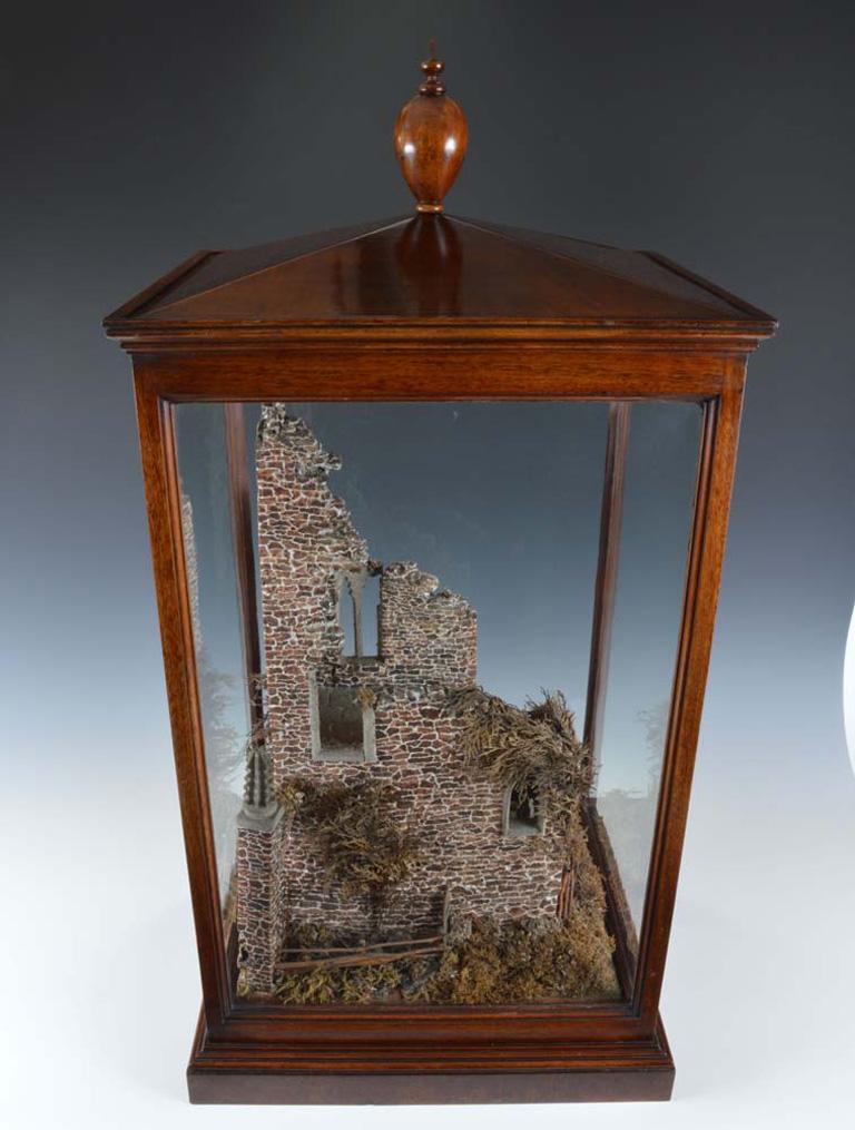 A superb quality and rare 19th century cork model of a castle ruins within a glazed mahogany case surmounted by a turned finial, the model of the castle with exceptional detail to the brickwork, windows and door, and from whatever angle this is