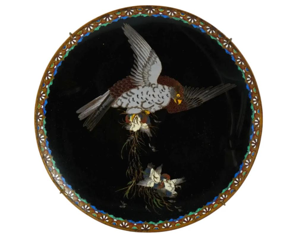 A rare antique Japanese Meiji era, enamel over copper charger plate. The exterior of the plate is adorned with a polychrome scene with an eagle and nestlings on black ground made in the Cloisonne technique. The border features traditional foliage,