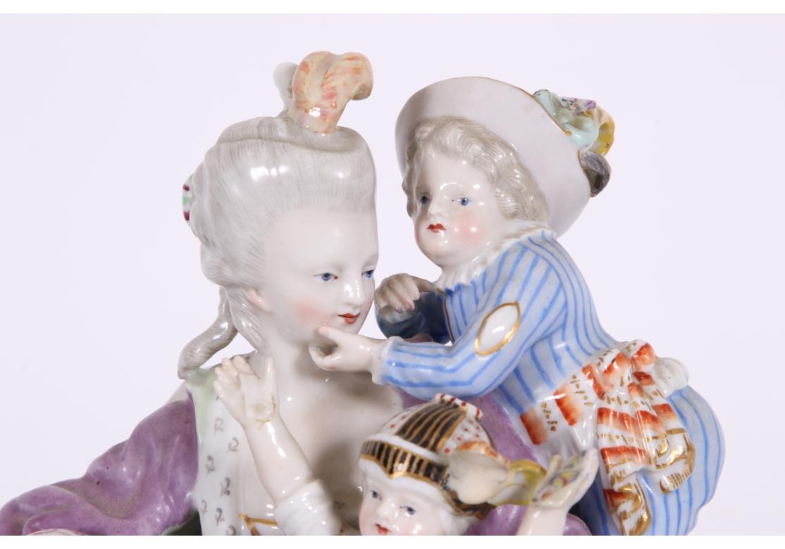 The mother seated in a fauteuil with a boy scrambling over her shoulder, a baby on her lap, an older boy sitting on a stool playing with a pack of cards which has fallen from the baby's lap.
The figure with underglaze blue crossed swords and incised