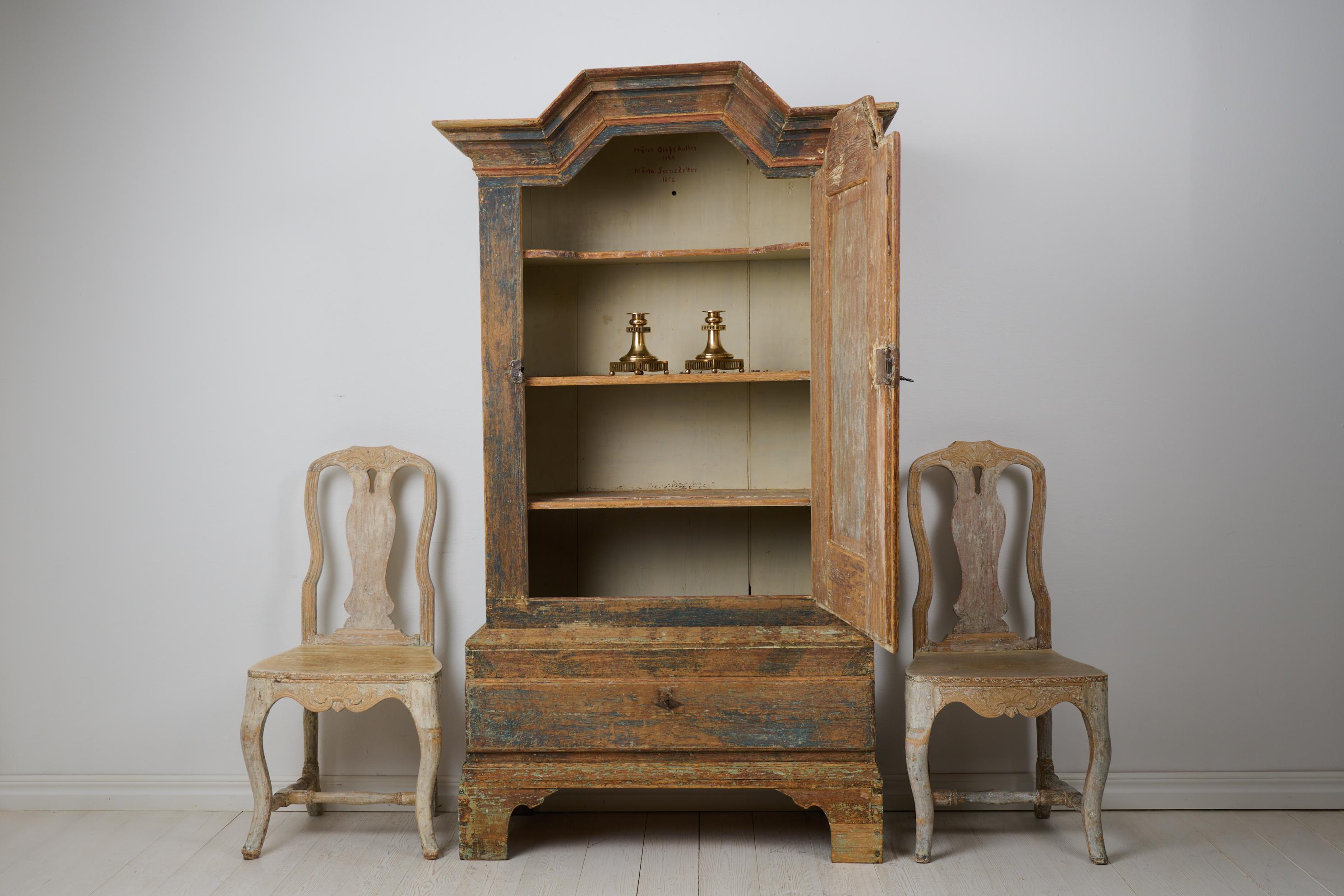 Raro mobile antico svedese in arte popolare della fine del 1700. Questo mobile d'arte popolare è in stile barocco e realizzato a mano in pino massiccio. Dalla Svezia settentrionale. L'armadio è realizzato in due parti e presenta la prima vernice