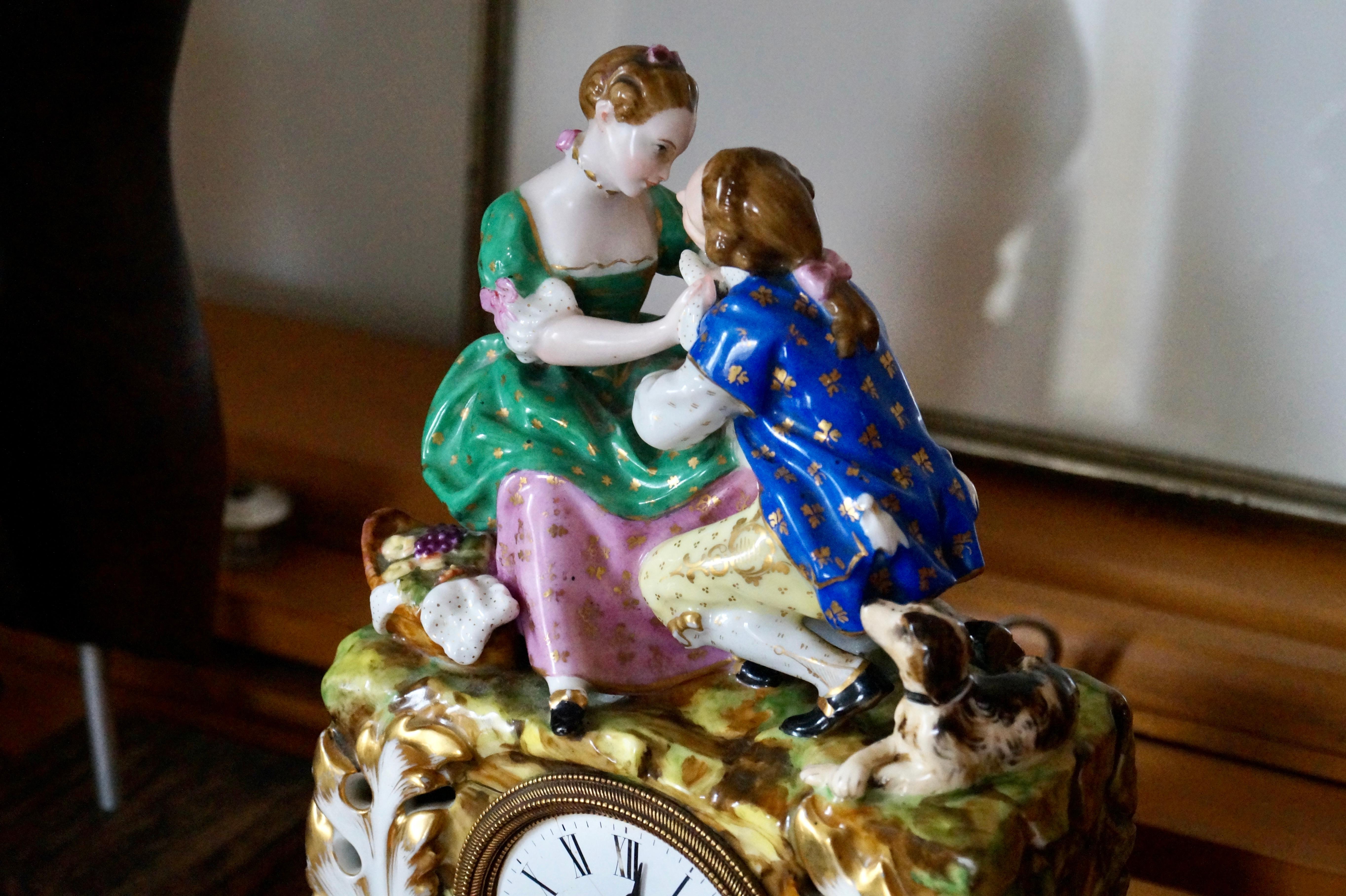 Beautiful antique clock of French Old Paris Porcelain (Porcelaine de Paris)

This clock is completely made of 1 pieces of porcelain with a couple in love, a dog and basket with fruit and flowers. The foot is hand painted with burgundy red and richly