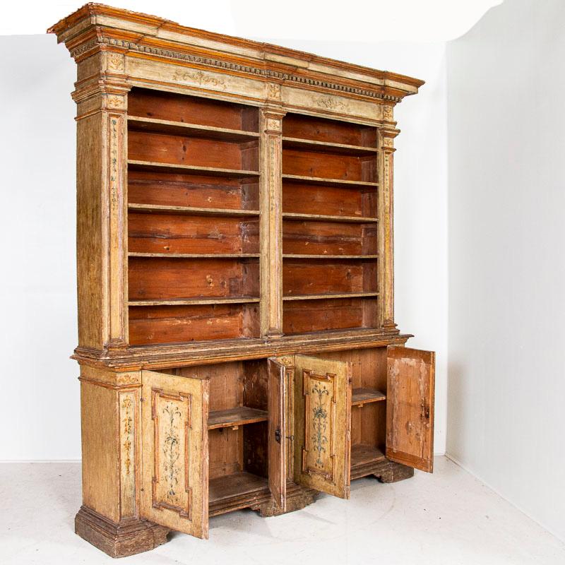It is rare to find an original painted bookcase of this quality, making this a special find. The original painted finish adds both grace and grandeur to this striking display cabinet from Italy. Muted colors of cream, ocher, blue and green add depth