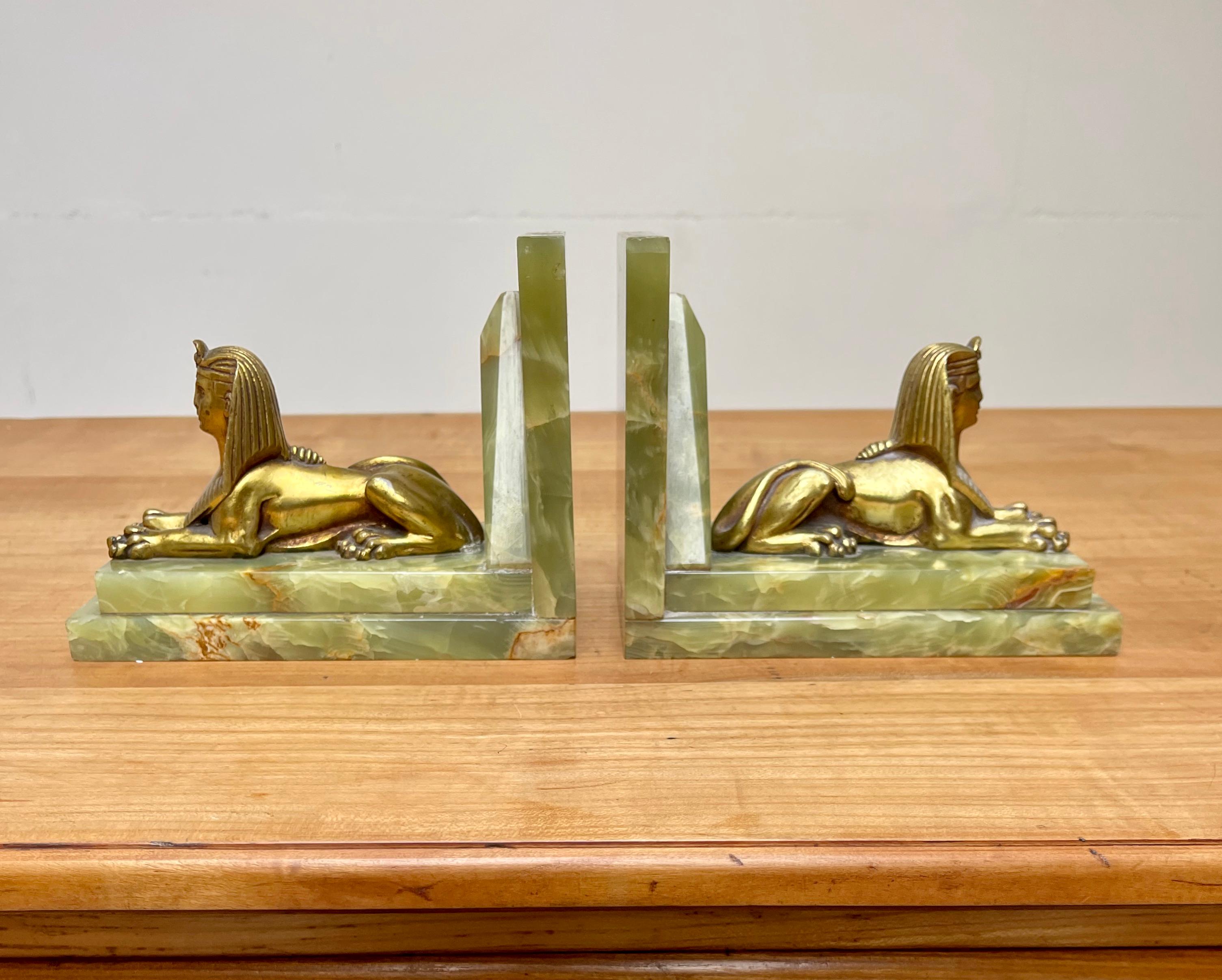 Beautiful pair of green onyx bookends with Egyptian sphinx sculptures.

These practical size, highly stylish and all handcrafted onyx marble bookends come with a pair of beautifully sculptured, gilt bronze sphinxes. 
Apart from practical to use