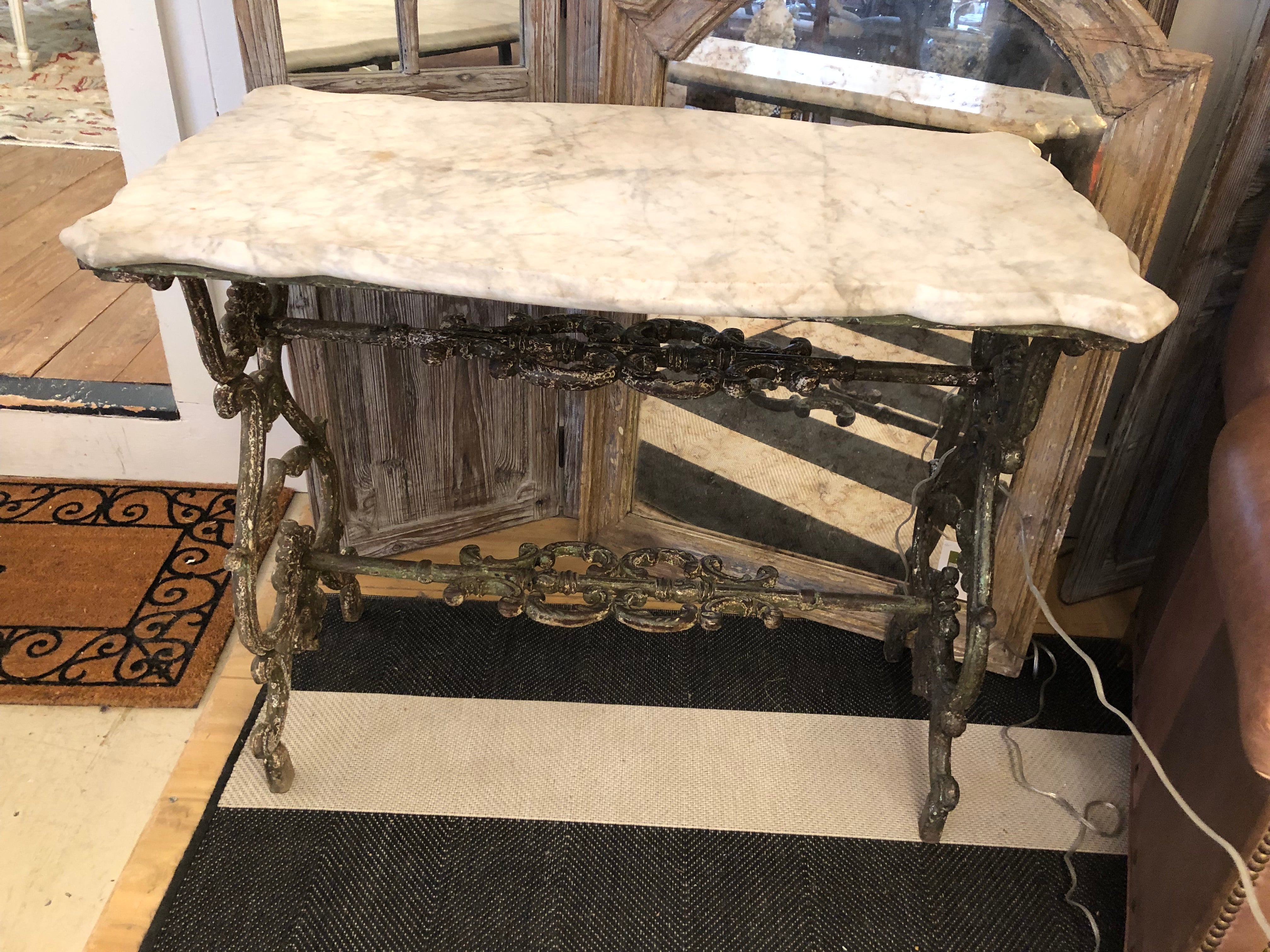 Rare and splendid French patisserie table having stunning curlicue cast iron base and scalloped bevelled rectangular marble top.  Would make a lovely console or small writing desk.