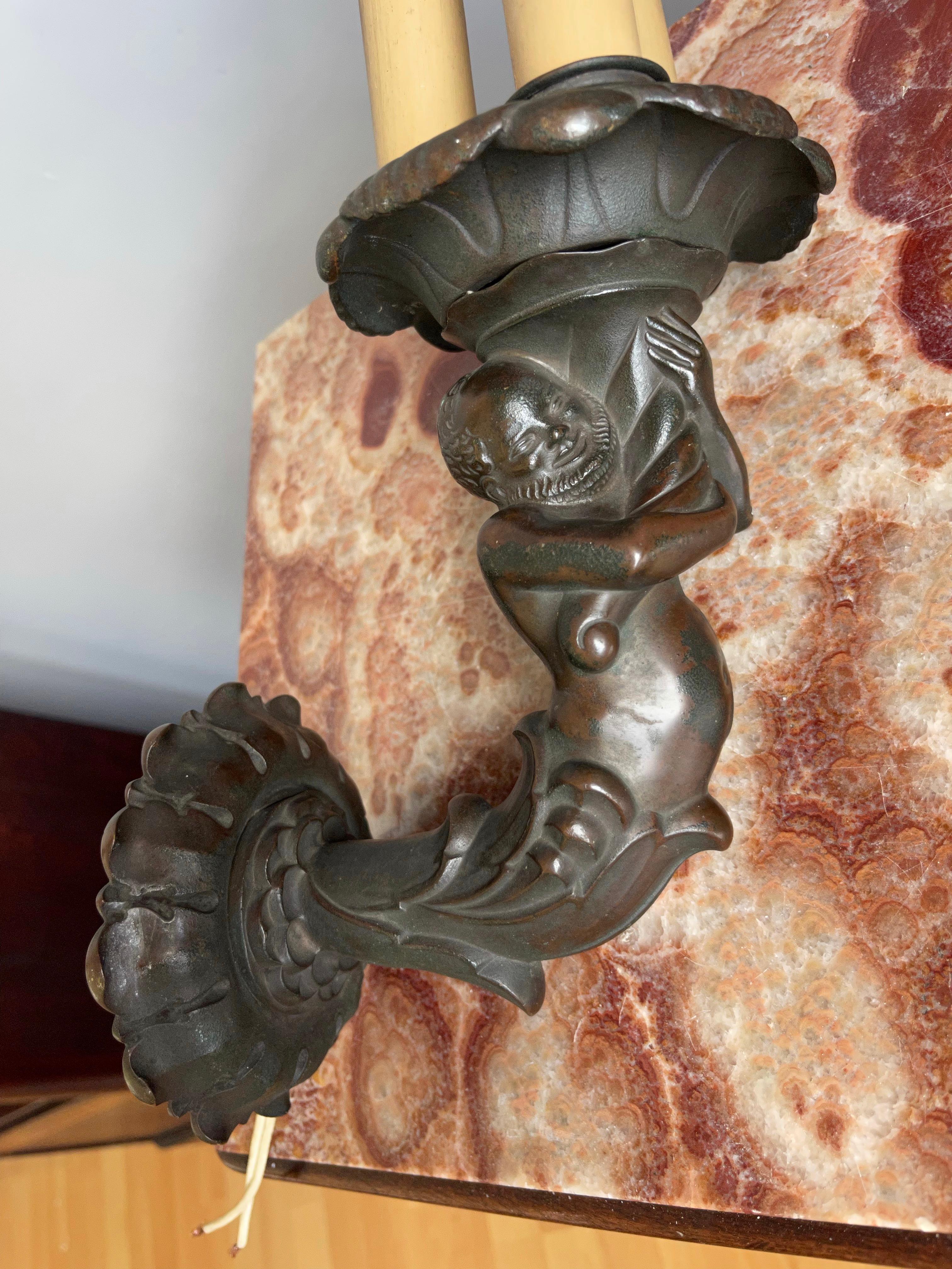Hochwertig verarbeitete, antike Bronzewandleuchte mit einer gnomartigen Figur, die einen lotusblumenartigen Schirm hält.

Die seltensten und stilvollsten Antiquitäten zu finden, ist etwas, das wir immer angestrebt haben. Wir denken schon lange