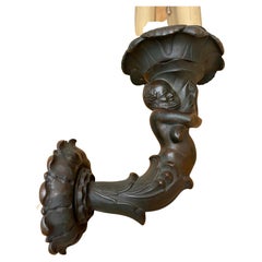 Rara figura maschile antica in bronzo patinato che regge una torchere, applique, apparecchio di illuminazione