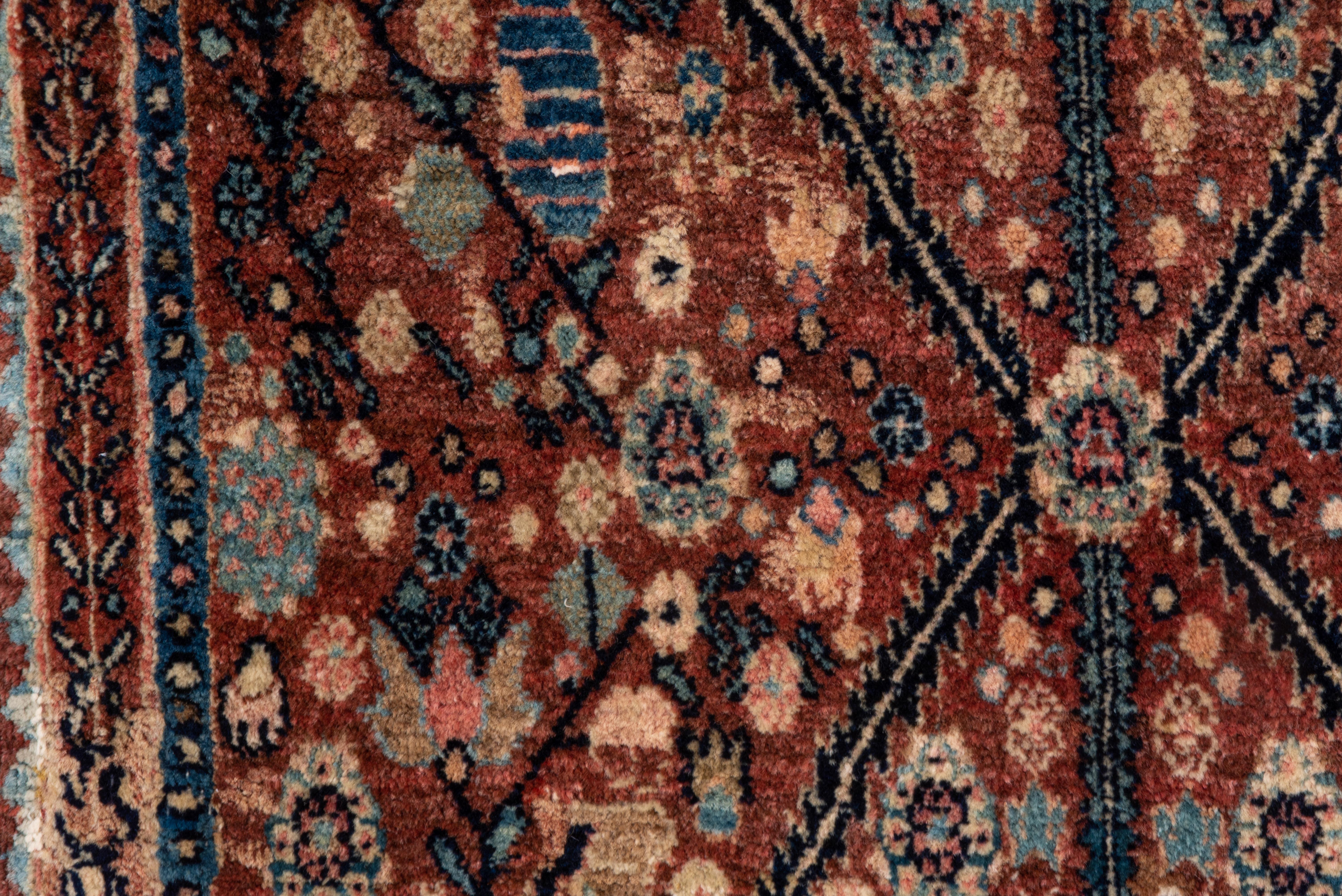 A rare Kurdistan Bidjar mat that is a full composition rather than a design sampler (wagireh). The red, flower filled field is centered by a thin 'X' pattern intersecting a vertical staff ending in boxy vases. Pale green and various blue accents.