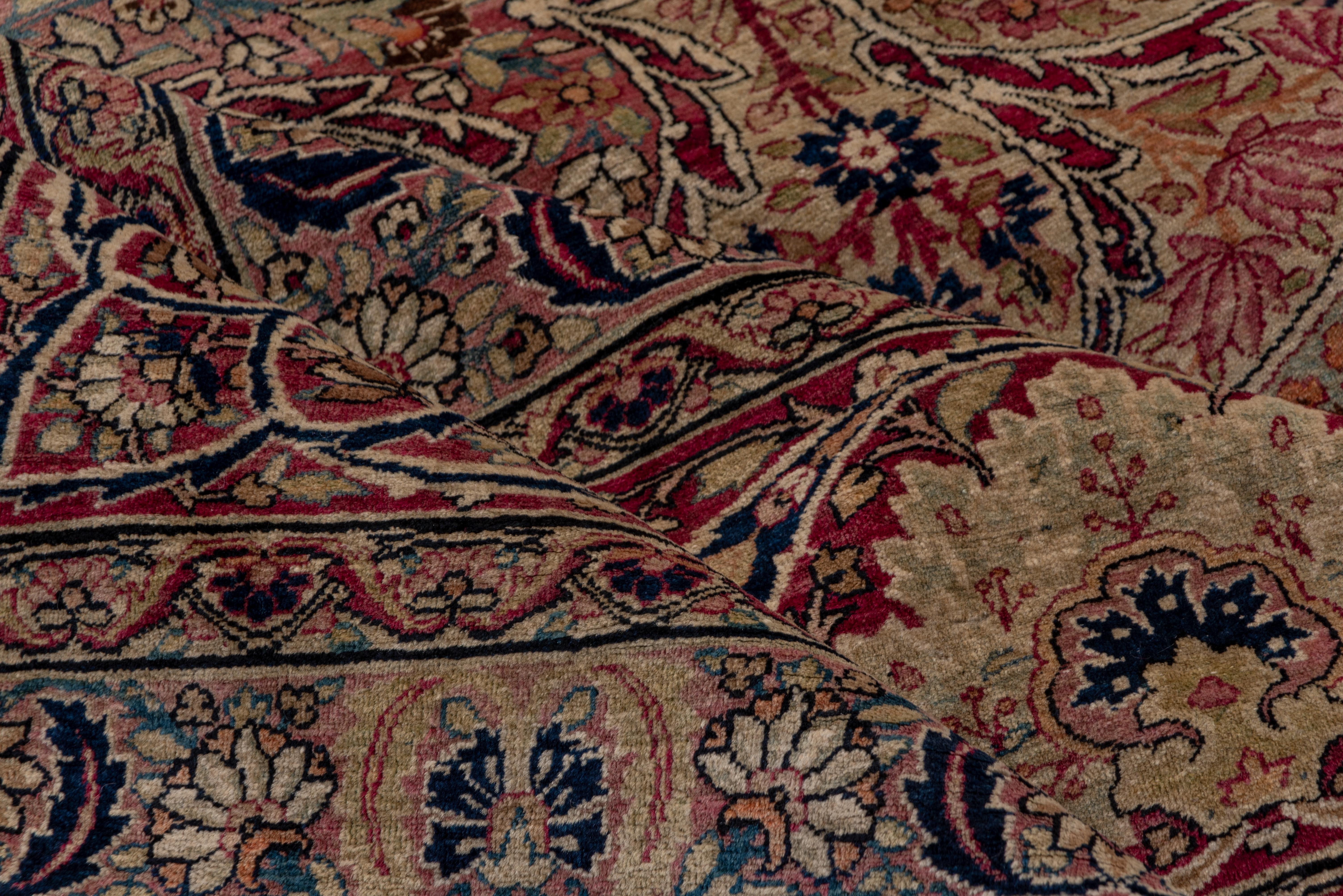 This Lavar quality SE Persian town carpet shows a unique and dense pattern of volute and curved leaves, flowering vases and concave diamonds. The cream field is detailed in navy, pistachio, wine red, rose, pink, teal, turquoise, medium blue, straw