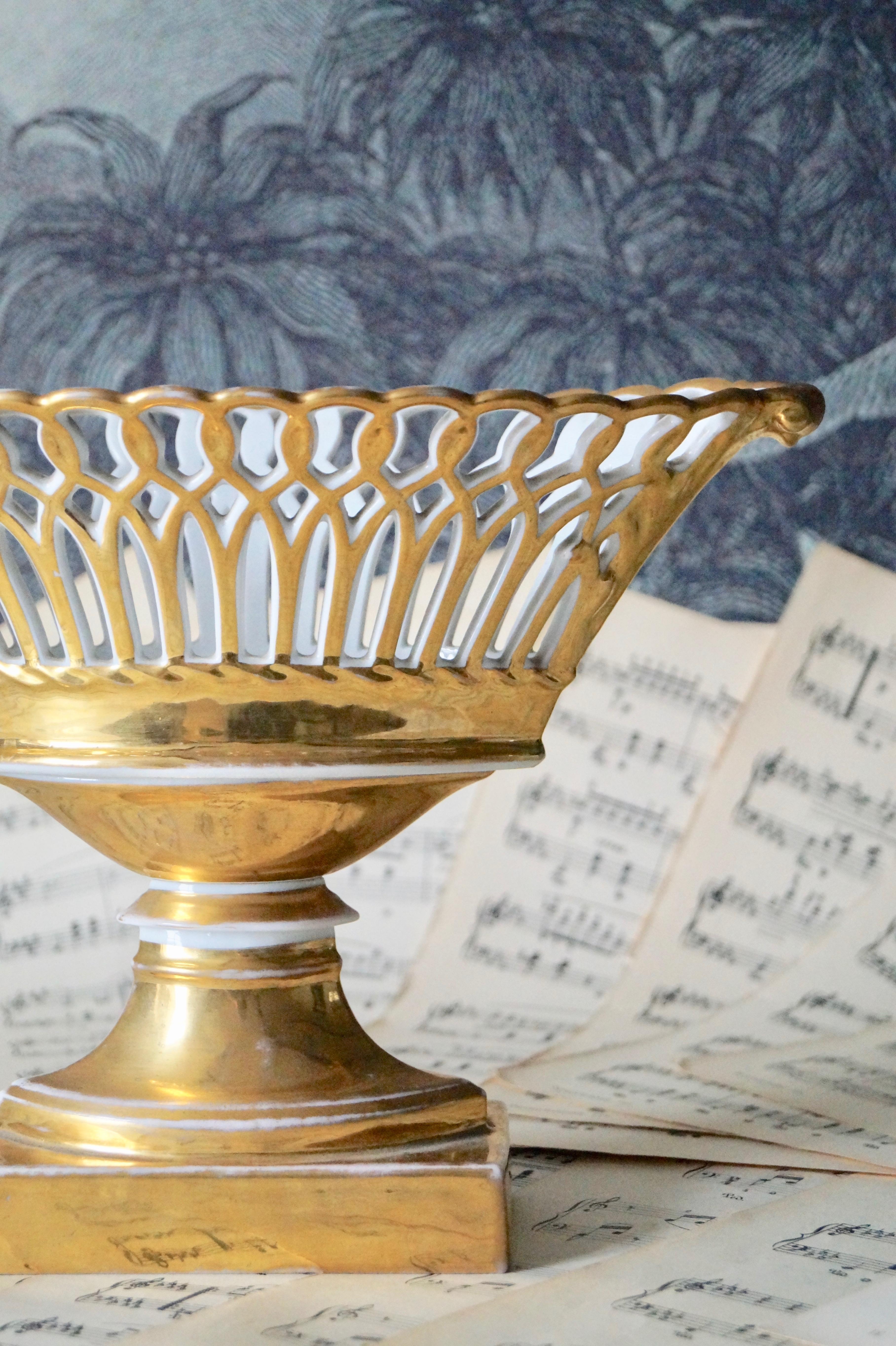 Stunning antique porcelain basket on high stand from the Empire Period (France) 1800-1820.

Beautiful oval shape on a high foot. Simple in it's form and richly gilded in gold. Typical from the French Empire era.

27,5x13cm - foot 13x6,5cm -