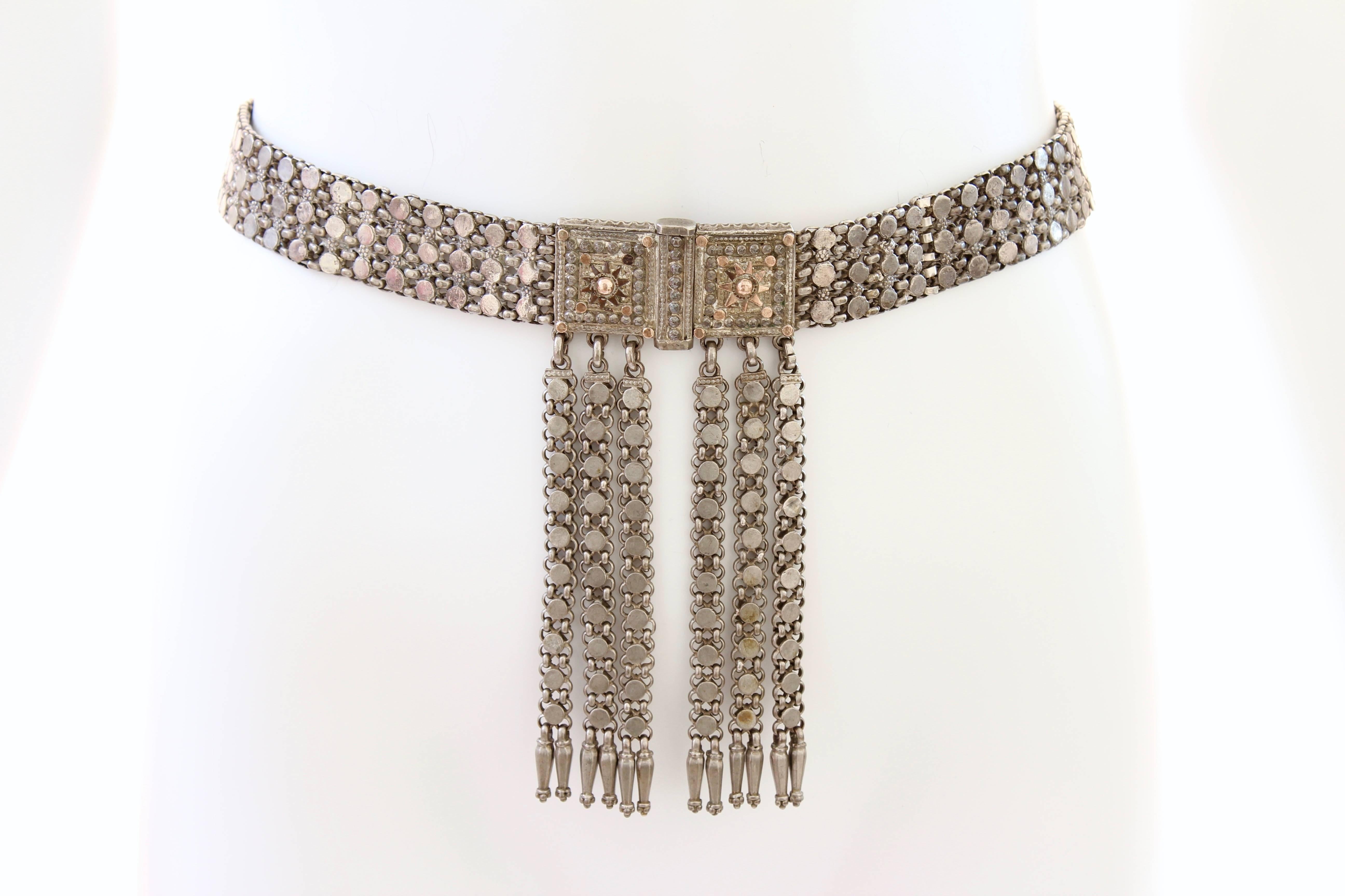 This eye-catching antique Rajasthan India belt features chains, floral motifs and dangles - perfect for festivals or events.  It fastens with a drop down bar and features 6.25in long dangles.  It best fits a 26in waist (cannot be adjusted).  No