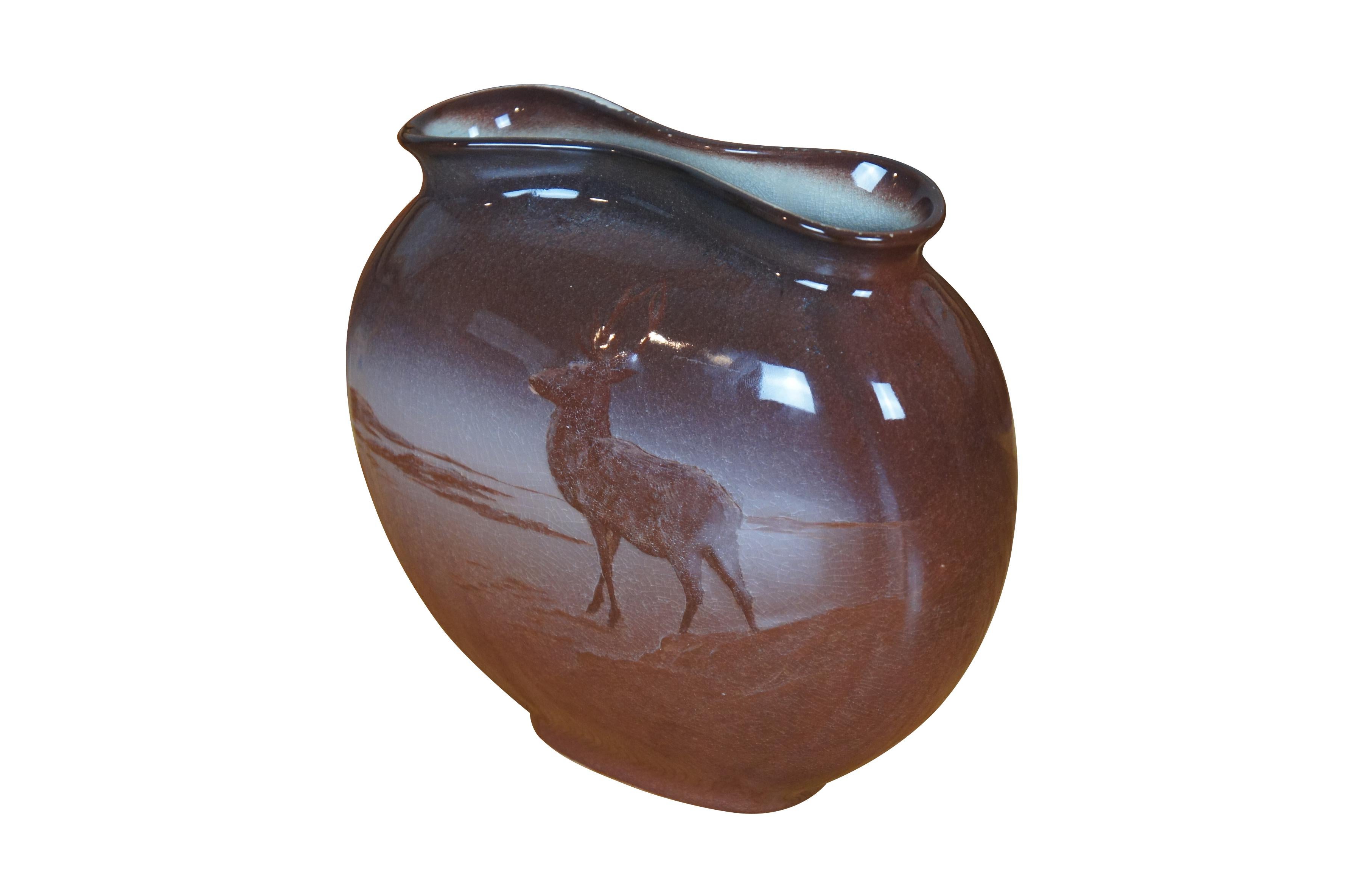 Antico vaso da camino / cuscino Kataro Shirayamadani di Rookwood con un disegno di caccia dei nativi americani con alci / cervi / cervi in un paesaggio desertico.  Codice forma 707, dimensione A, firmato in giapponese dall'artista.

Dimensioni:
8