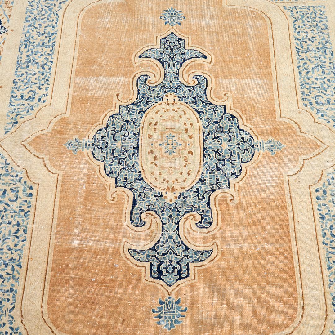 Blush pink rust and blue medallion have been woven into a highly detailed design in this antique area rug, handwoven in Iran in 1900. The Tabriz rug features a stunning central medallion design woven on a rust background with beige/blue borders. The
